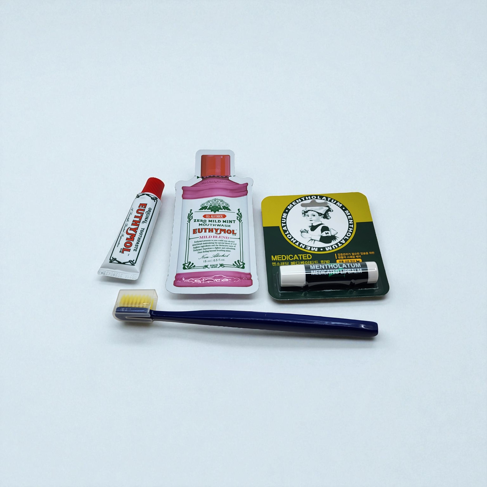 유시몰 덴탈 케어 세트와 멘소래담 립밤, 칫솔 구성품을 위에서 정면으로 본 모습