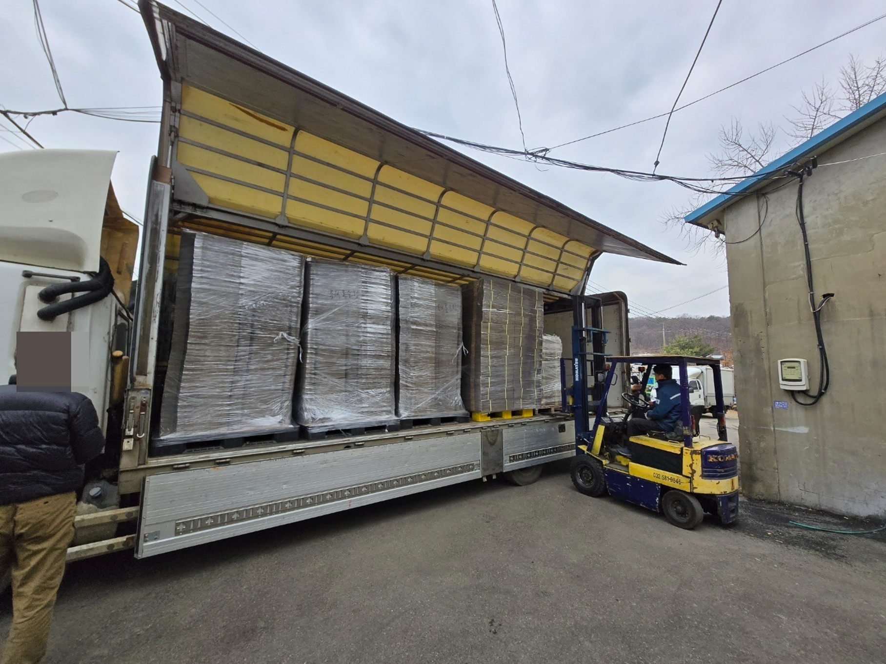 종이박스 납품을 위해 지게차로 상차하는 작업 장면