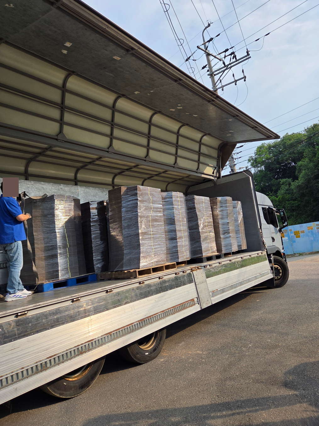 낮은 높이의 넉다운 박스를 트럭에 적재해 납품하는 현장 모습