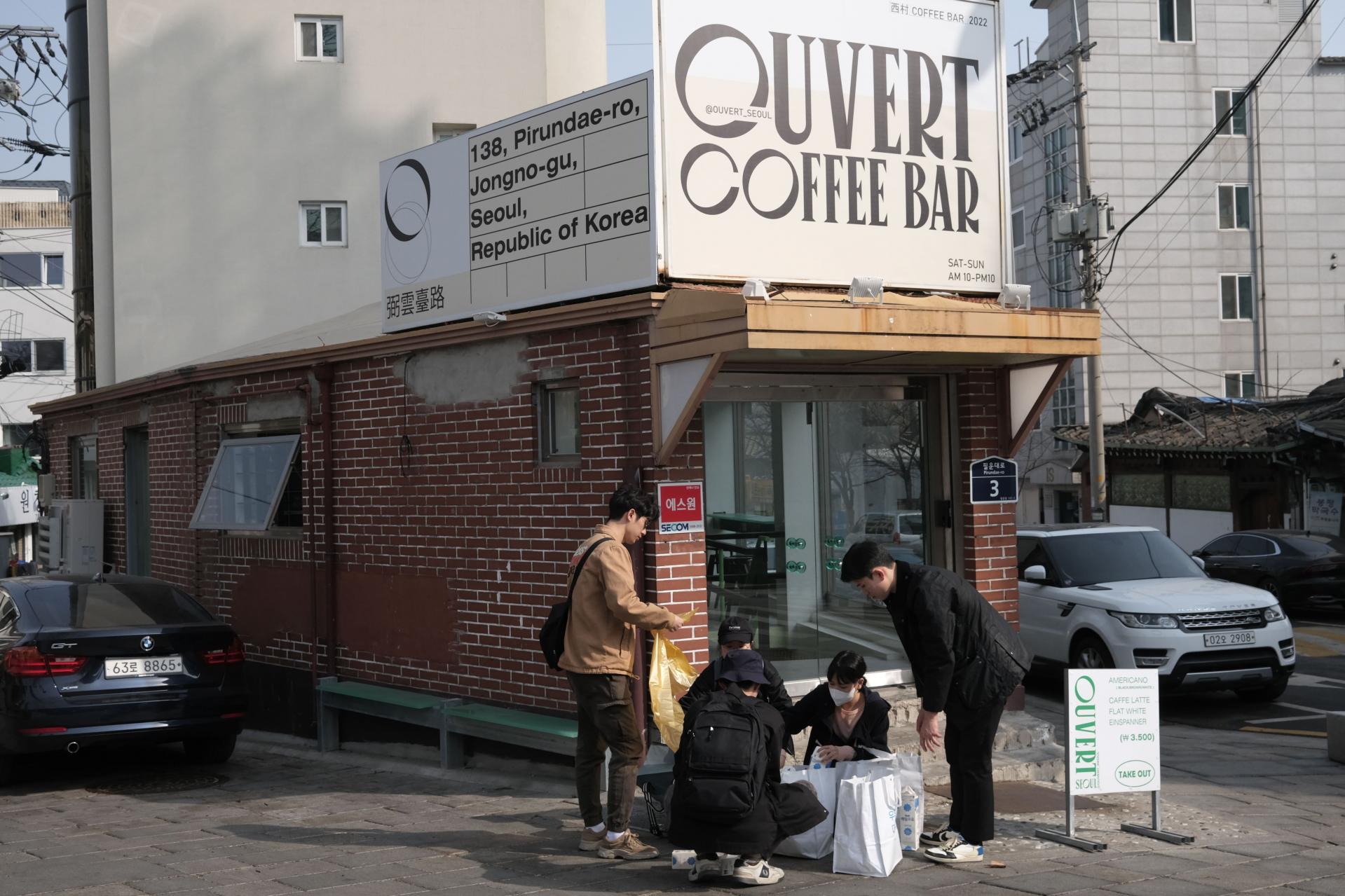 카페 앞에서 종이팩을 수거하고 있는 지구봉사단 봉사자들