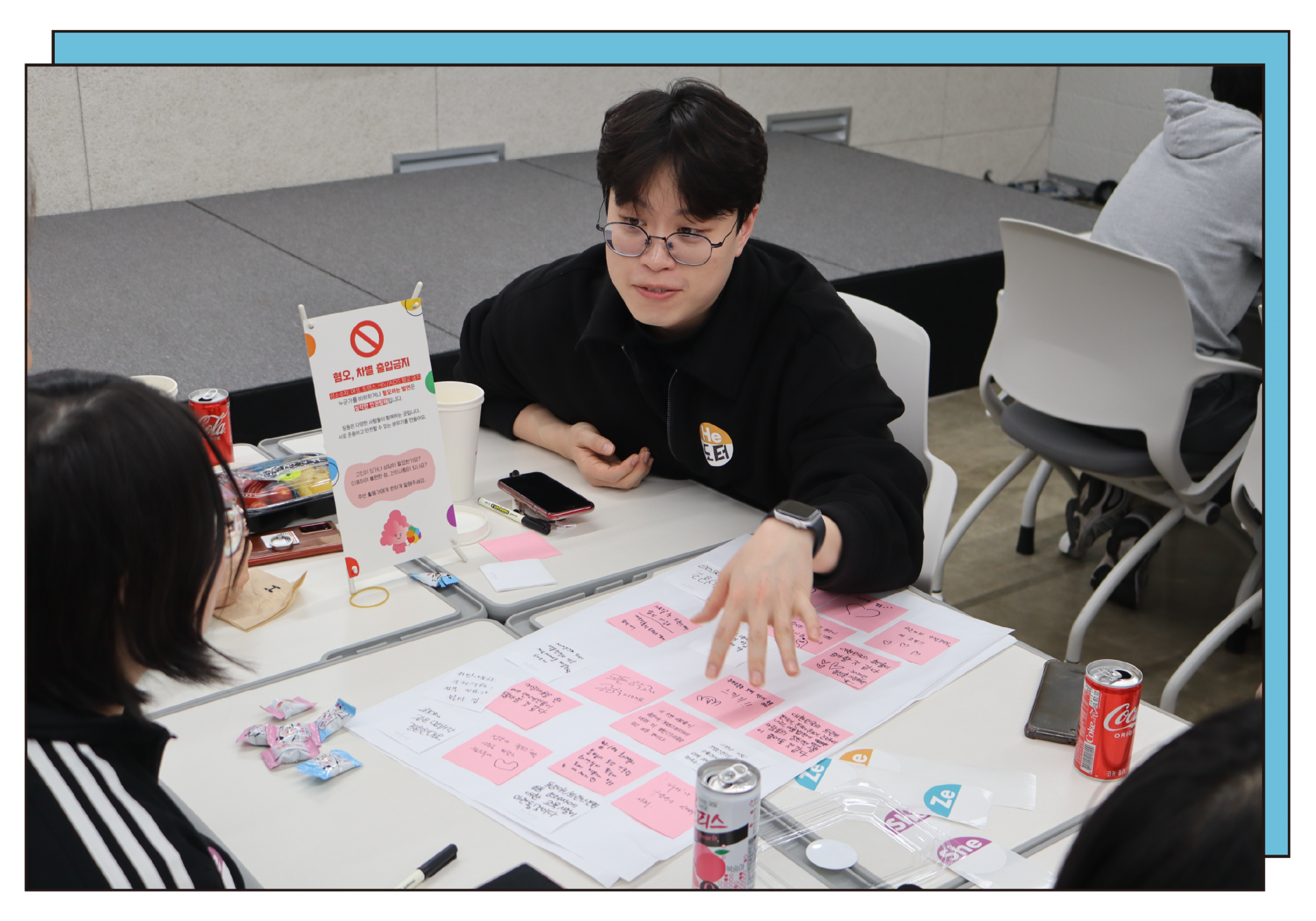 A photo of a DDing Dong activist attentively listening to an LGBTQ+ youth at the DDing Dong restaurant.