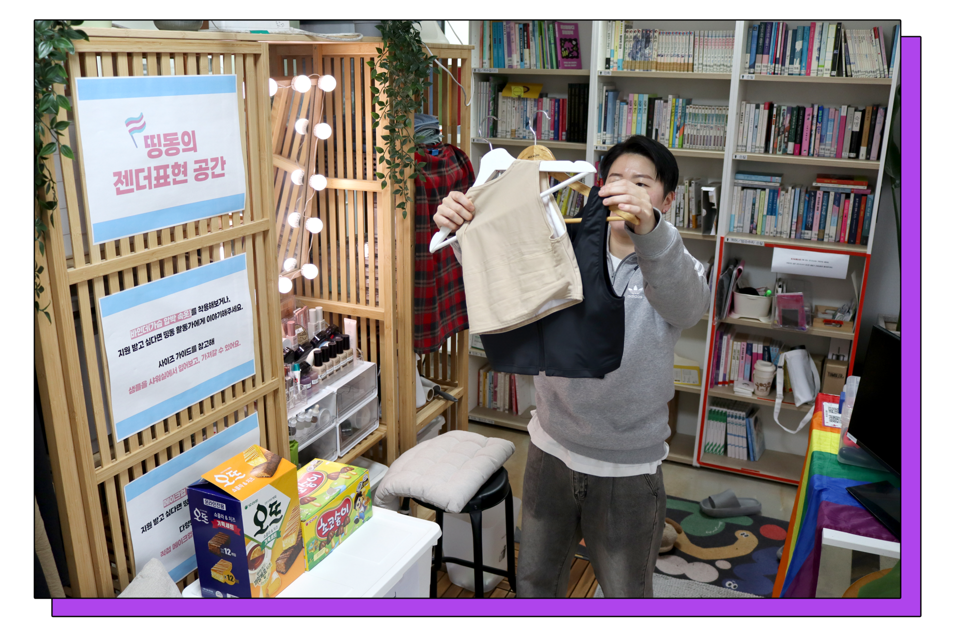 A Dding Dong activist organizing a binder in an open space with snacks, books, and a sofa.