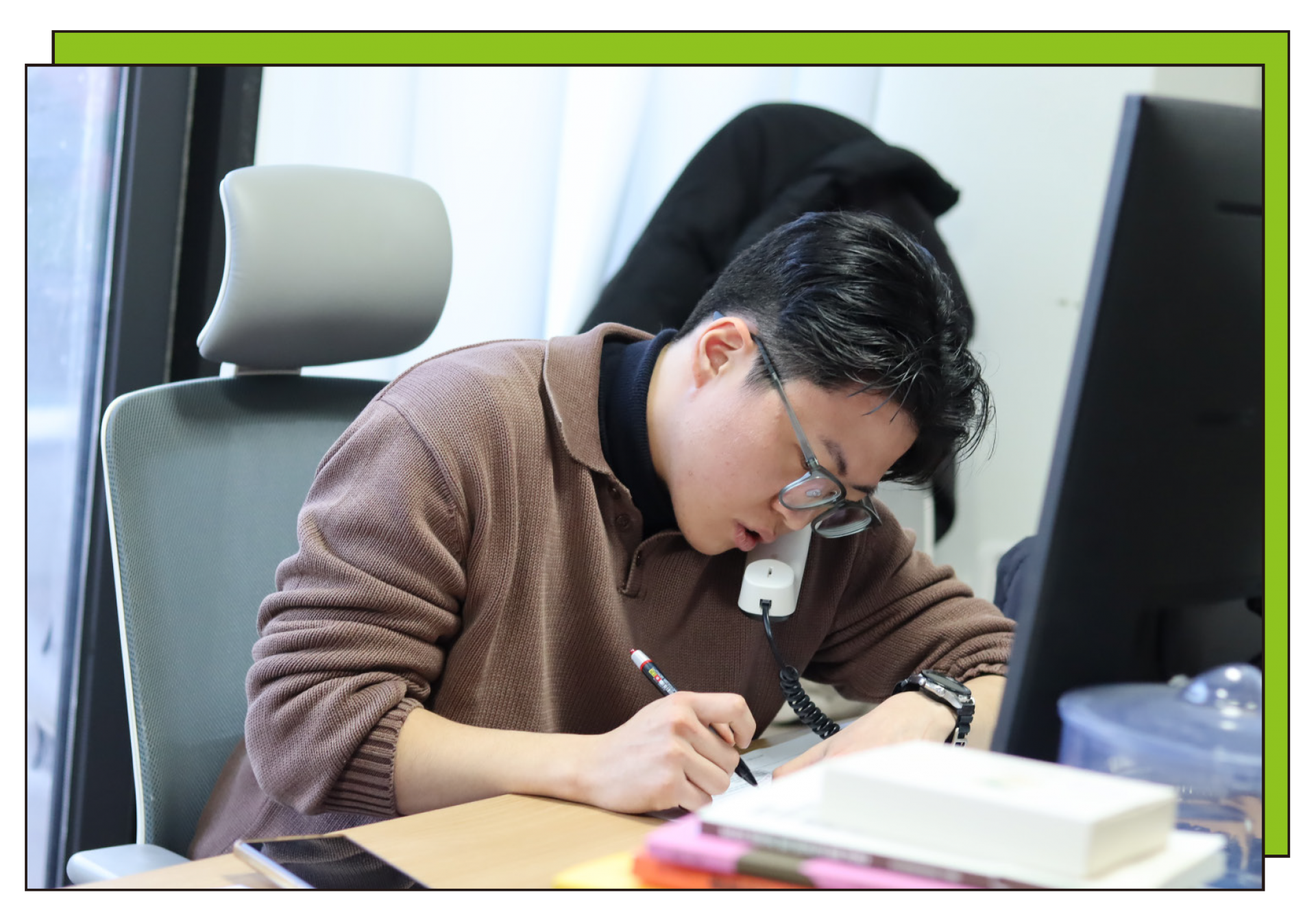 A DDing Dong activist holding a phone to their ear while taking notes.