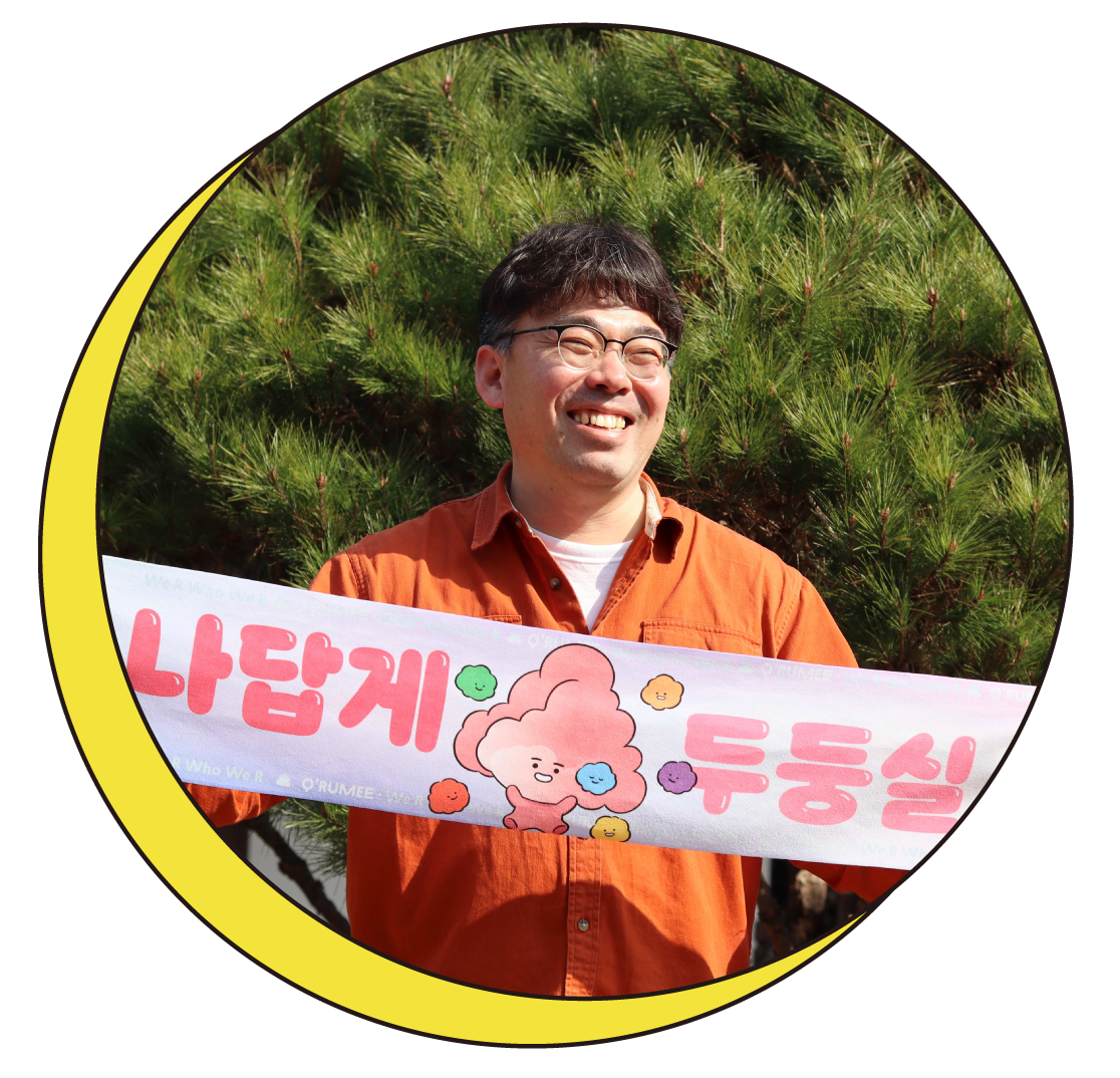 띵동 이사장 정민석 씨가 '나답게 두둥실'이라는 현수막을 들고 웃고 있는 모습을 담은 사진