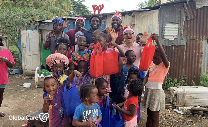 마을을 찾은 산타닥터스에게 식료품을 선물받은 아이티 난민 어린이들