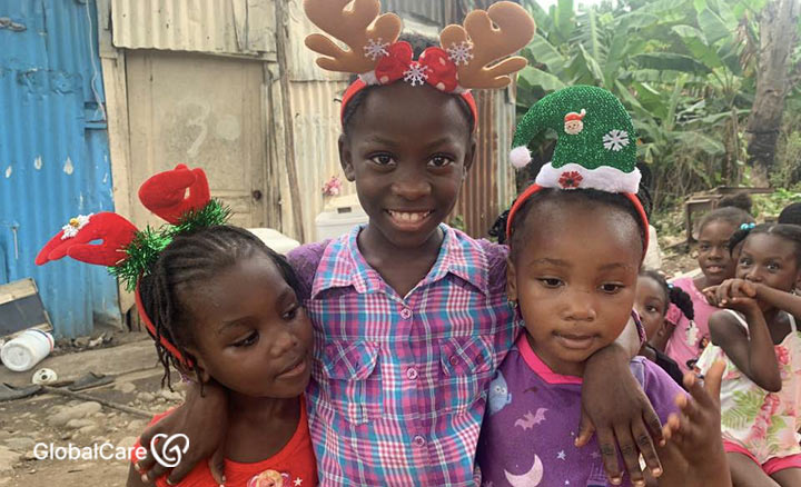 크리스마스 장식을 쓰고 환하게 웃고 있는 아이티 난민 어린이들