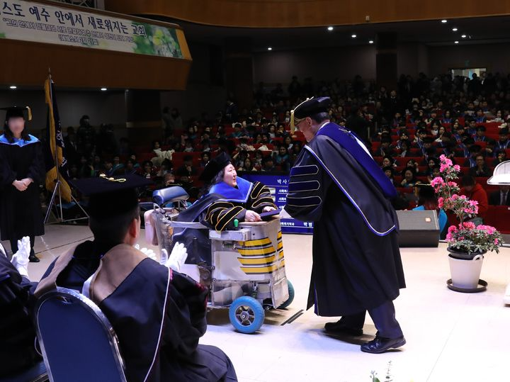 [용인=뉴시스] 지난 19일 경기 용인시 기흥구 강남대학교 우원관 대강당에서 열린 '2023학년도 전기 학위수여식'에서 윤신일 총장이 이진영 박사에게 우수논문상을 수여하고 있다. (사진=강남대 제공) 2024.02.27. photo@newsis.com *재판매 및 DB 금지