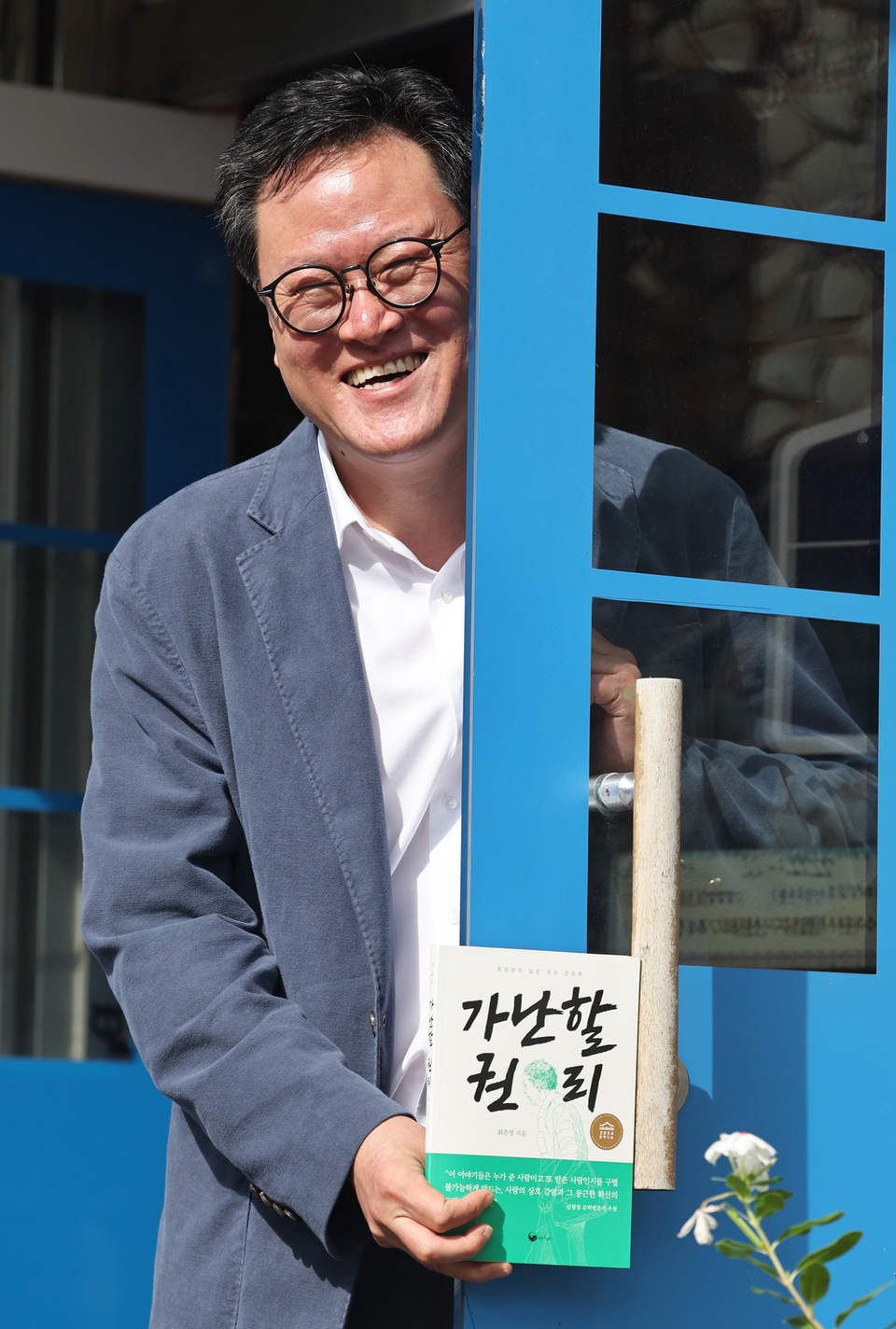 ▲ '거리의 인문학자' 최준영 책고집 대표가 지난 20여 년간 만난 노숙인·재소자 등의 이야기를 쓴 '가난할 권리' 책을 들고 수줍게 웃고 있다./김철빈 기자 narodo@incheonilbo.com