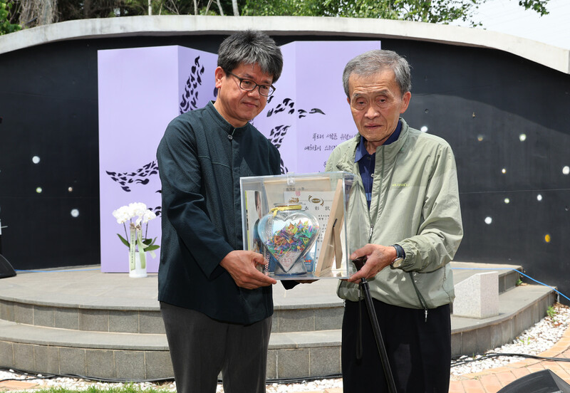 고 신효순양의 아버지 신현수씨(오른쪽)가 13일 경기도 양주시 광적면 효촌리 효순미선평화공원에서 열린 고 신효순·심미선 23주기 추모제에서 효순양 유품인 종이학을 공개하고 있다. 정용일 선임기자 yongil@hani