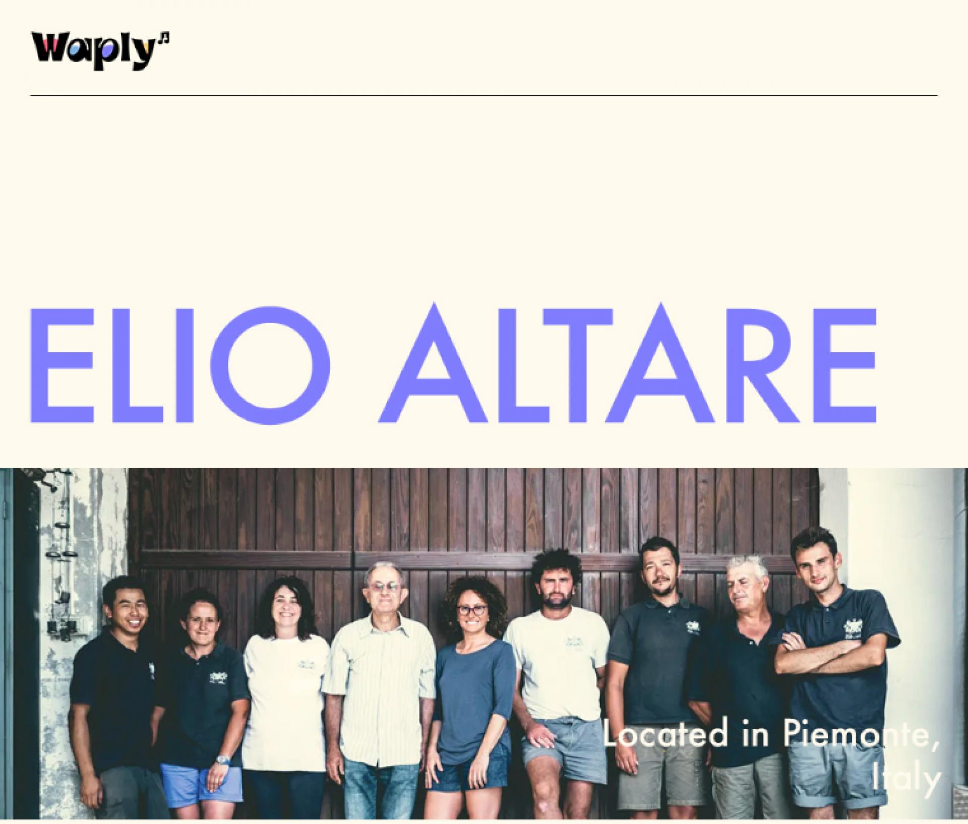 Waply 브랜드 로고가 있는 헤더와 함께, 'ELIO ALTARE'라는 큰 파란 글자가 담긴 이미지입니다. 로고 아래에는 여덟 명의 사람들이 나란히 서 있는 모습이 포착되어 있으며, 이들은 카메라를 향해 다양한 표정으로 서 있습니다. 배경은 목재로 된 건물의 외부로 보이며, 문에는 희미하게 페인트가 벗겨져 역사를 느낄 수 있는 질감을 보여줍니다. 이미지 하단에는 'Located in Piemonte, Italy'라는 텍스트가 추가로 있어, 이 사람들이 이탈리아 피에몬테 지역에 위치한 것으로 추정됩니다