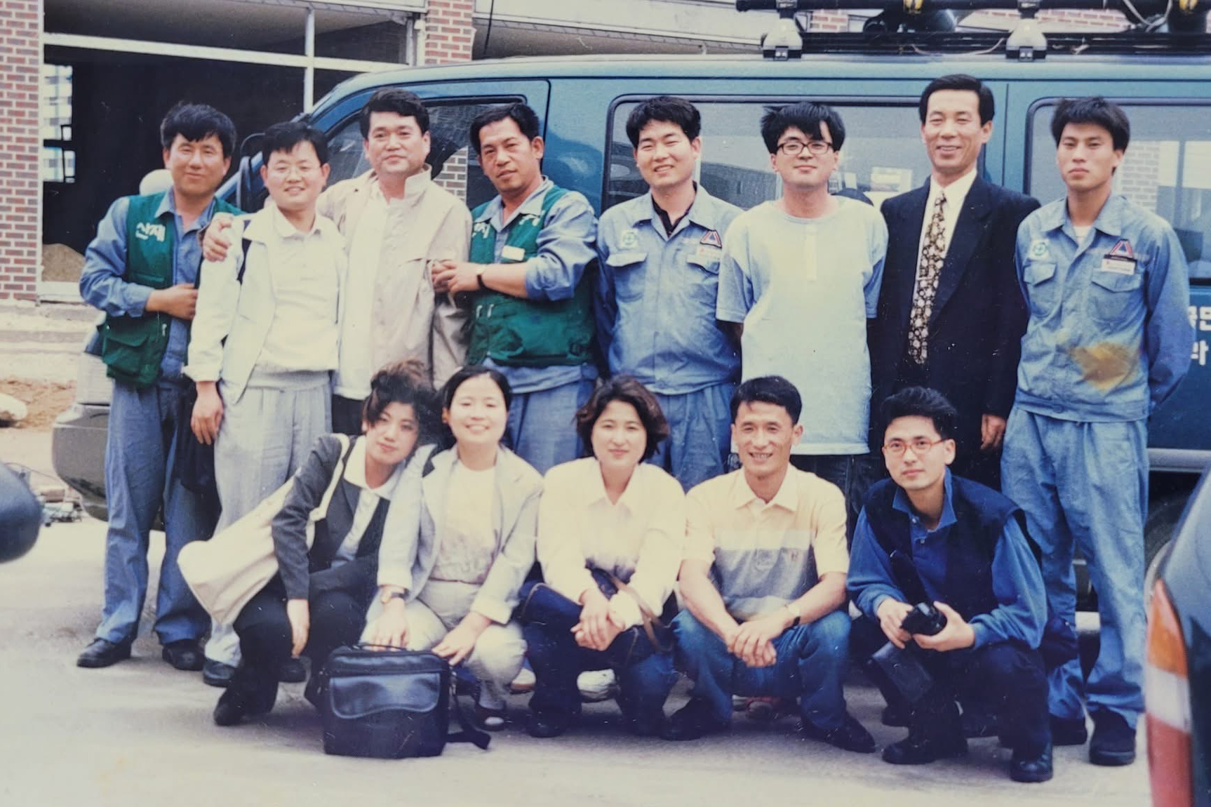 과거에 찍은 단체사진. 첫째줄에 남녀 5명이 앉아있고, 둘째줄에 남성 8명이 서있다.