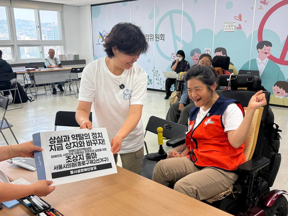 지난 5월 15일, 조상지 씨가 선거관리위원회를 찾아 후보자 등록을 하고 있다. 후보자 등록 서류가 담긴 봉투에는 “상실과 약탈의 정치 지금 상지와 바꾸자!”라고 적혀 있다. 사진 탈시설장애인당