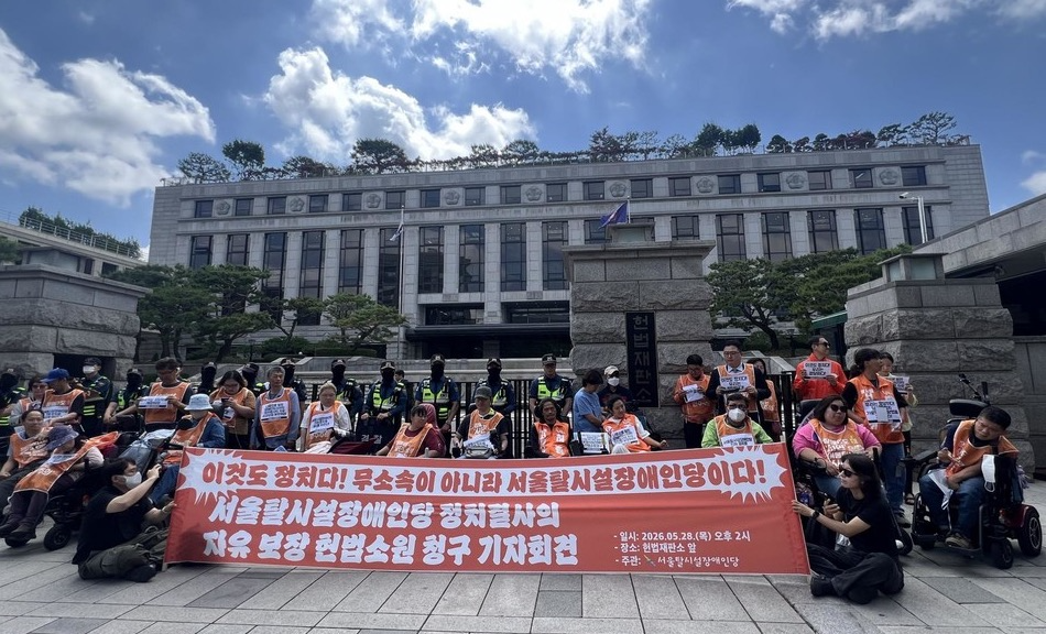 지난 5월 25일 헌법재판소 앞에서 서울탈시설장애인당 활동가들이 ‘서울특별시 탈시설지원조례 폐지조례안’의 효력 정지를 촉구하는 기자회견을 열고 있다. 현수막에는 “이것도 정치다! 무소속이 아니라 서울탈시설장애인당이다!”라고 적혀 있다. 사진 탈시설장애인당