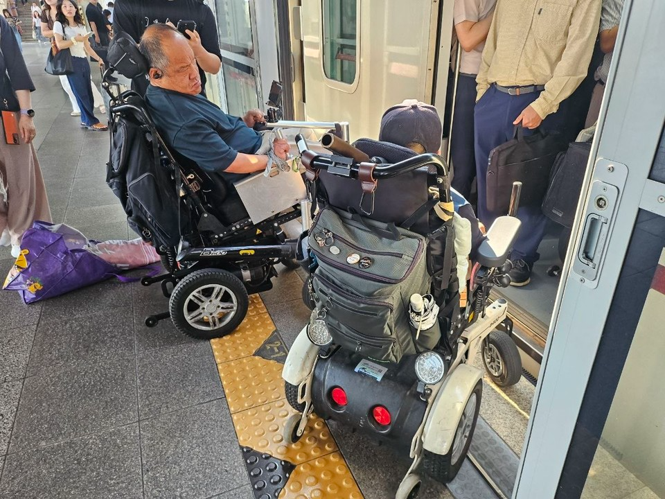 지난 3일 ‘70차 출근길 지하철 탑니다’ 당시 노량진역. 지하철 승강장에서 휠체어를 이용하는 장애인 활동가 두 명이 지하철 출입문 앞에 멈춰 서 있다. 객차 안은 승객들로 붐벼 휠체어 이용 공간이 확보되지 않은 모습이다. 사진 전국장애인차별철폐연대
