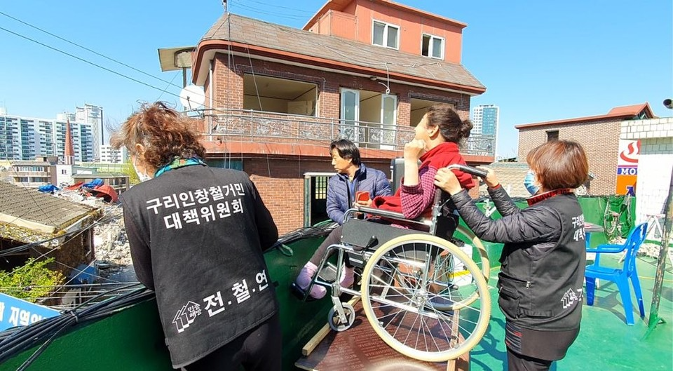 망루농성 당시 구리경찰서의 강제조사에 조상지 씨가 AAC(보완대체의사소통) 기기로 “우리는 폭도가 아니다”라고 외치고 있다. 사진 조상지