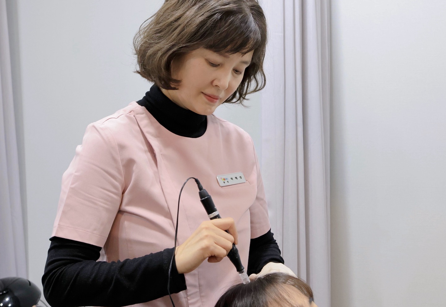 여자원장이 모낭주사로 여성탈모환자를 치료하느 사진