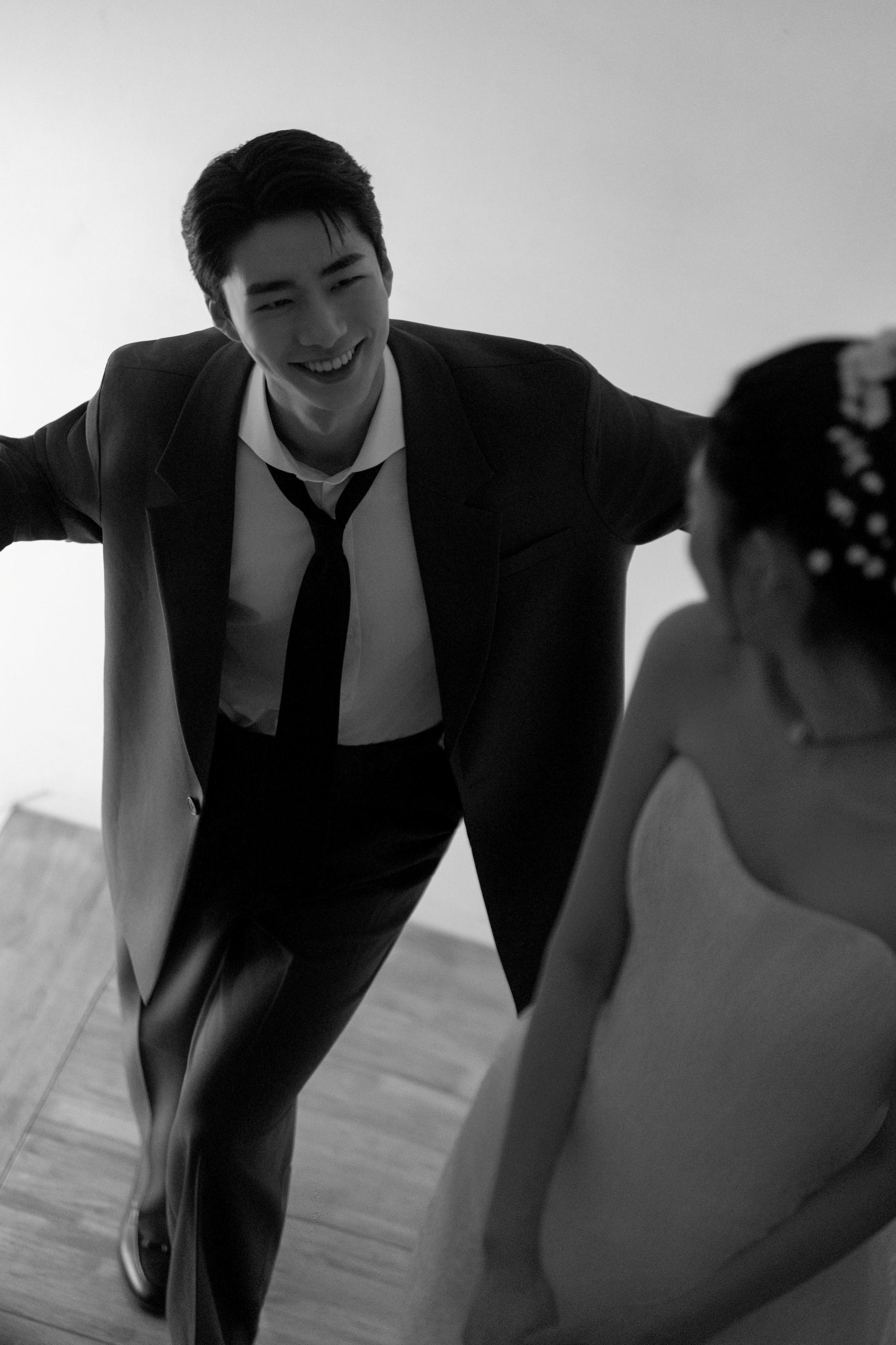 로렌하우스 웨딩 스튜디오 수트를 입은 신랑이 미소를 지으며 신부를 바라보는 모습을 흑백 감성으로 담은 웨딩 사진