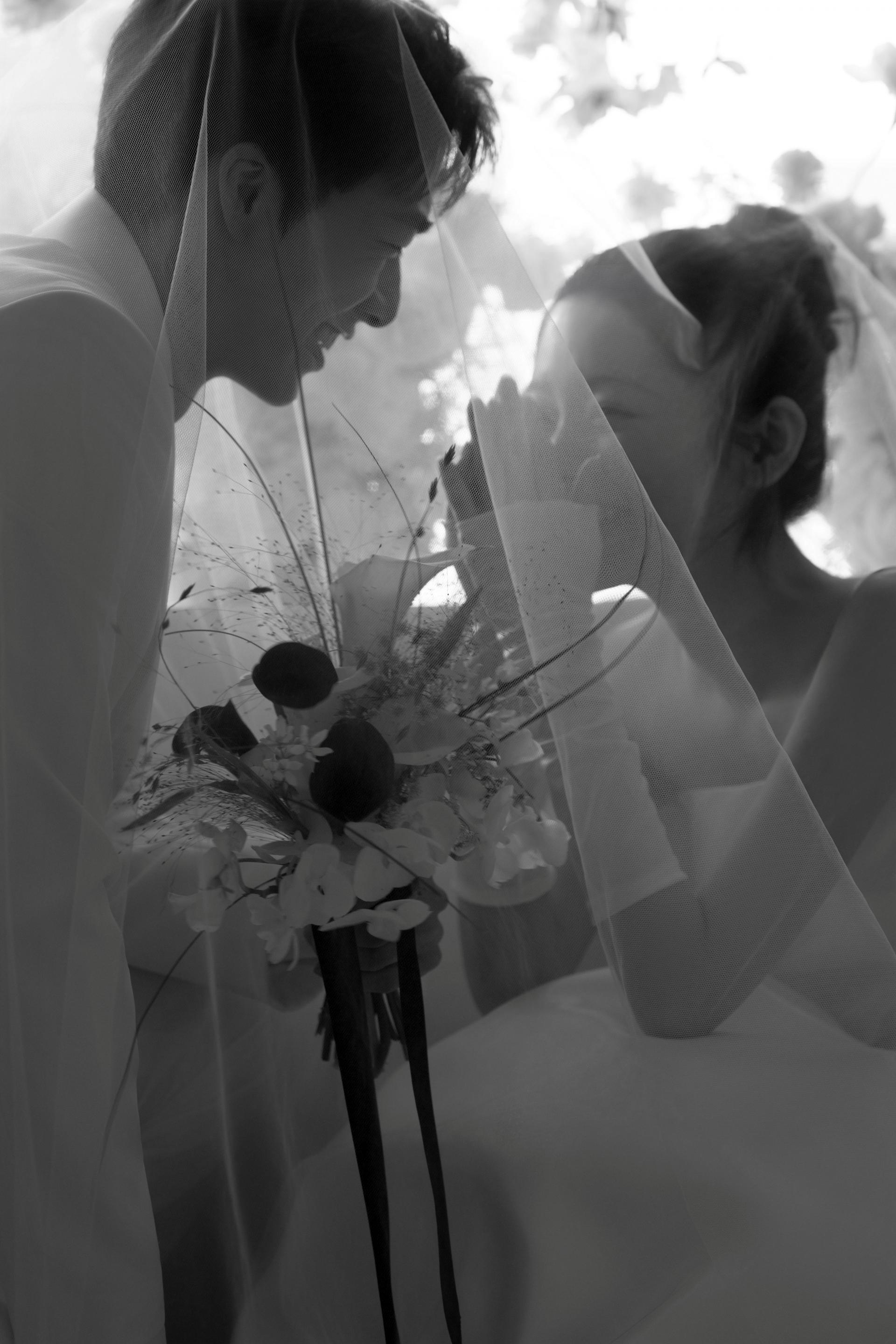 로렌하우스 웨딩 스튜디오 베일을 쓰고 부케를 든 신부와 신랑이 마주보고 있는 모습을 흑백 감성으로 담은 커플 웨딩 사진