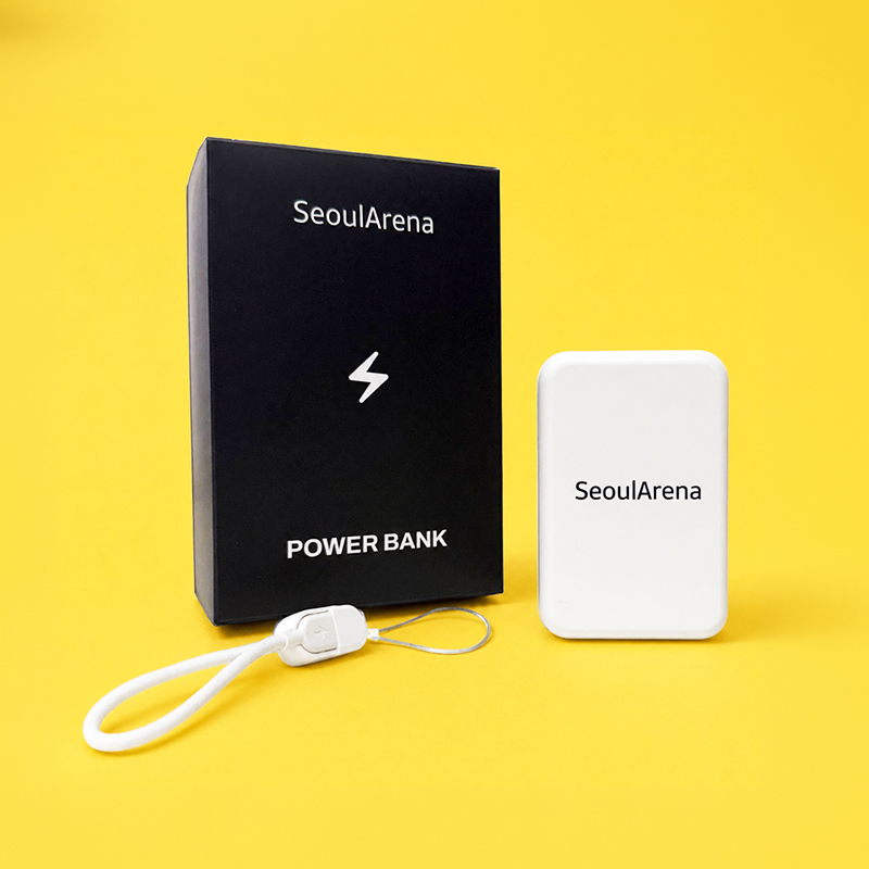번개 아이콘 픽토그램이 인쇄된 전용 블랙 단박스와 그 옆에 놓인 'SeoulArena' 로고 디자인의 컴팩트한 화이트 맥세이프 보조배터리 뷰.