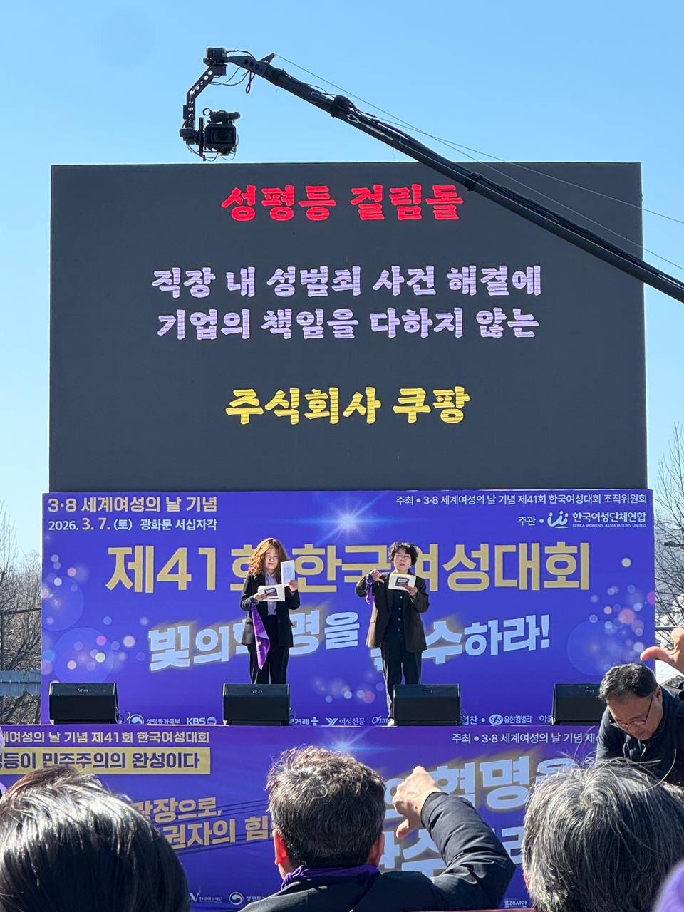 사진 25. 올해의 성평등 걸림돌을 무대에서 발표하고 있다. 주식회사 쿠팡이 스크린에 게시되어있다.