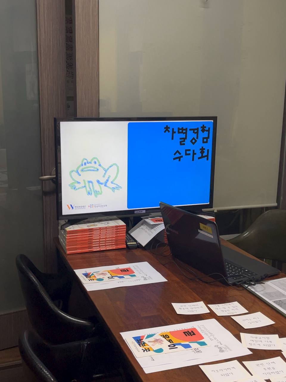 차별 경험 수다회라고 적힌 화면 아래로 민우회를 소개하는 브로슈어와 민우회 약속문, 트랜스 프렌들리 에티켓 출력물이 놓여 있다