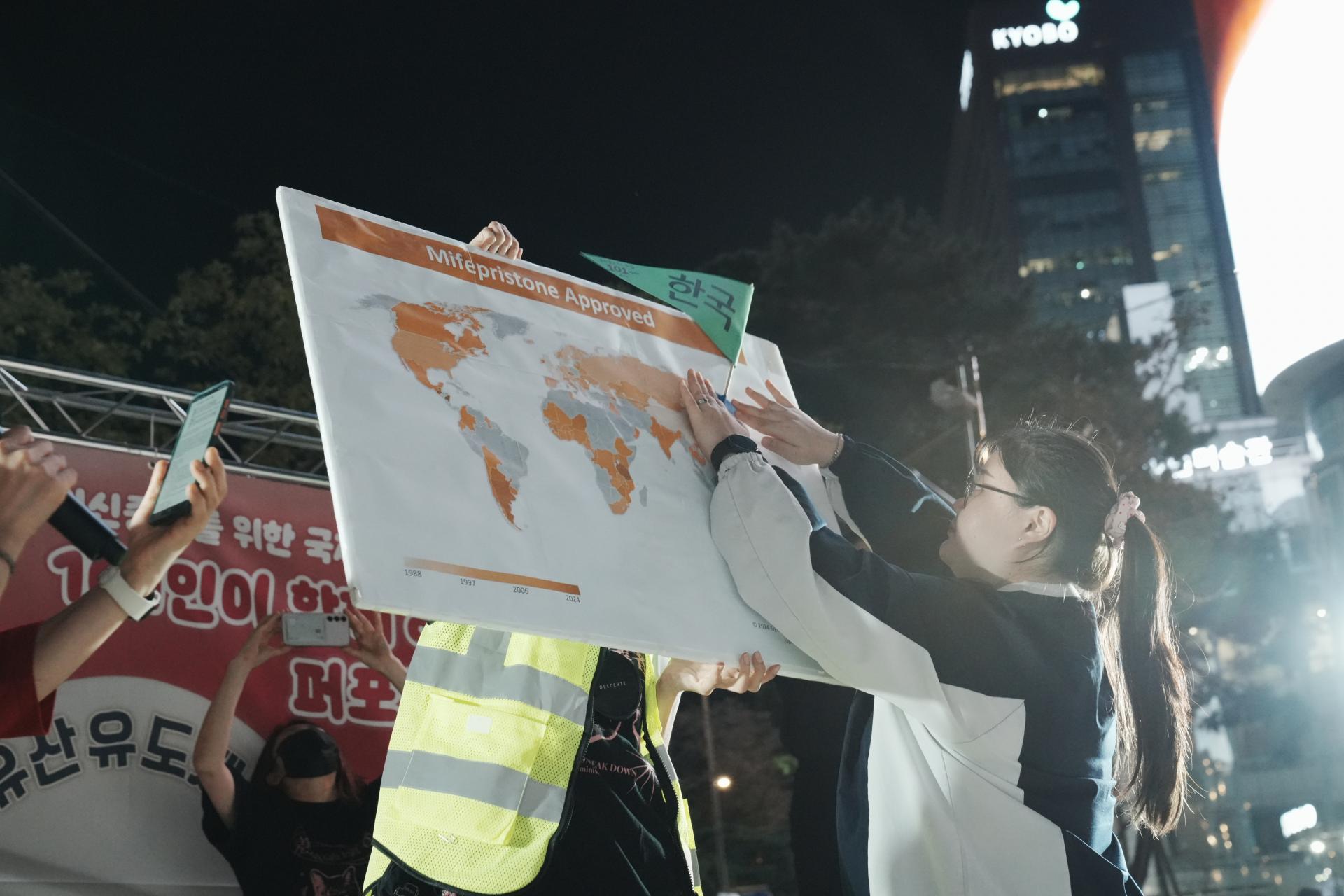 한 참여자가 한국이라고 적힌 삼각형 모양의 깃발을 미페프리스톤 승인국가가 표시된 지도에 꽂고 있다.