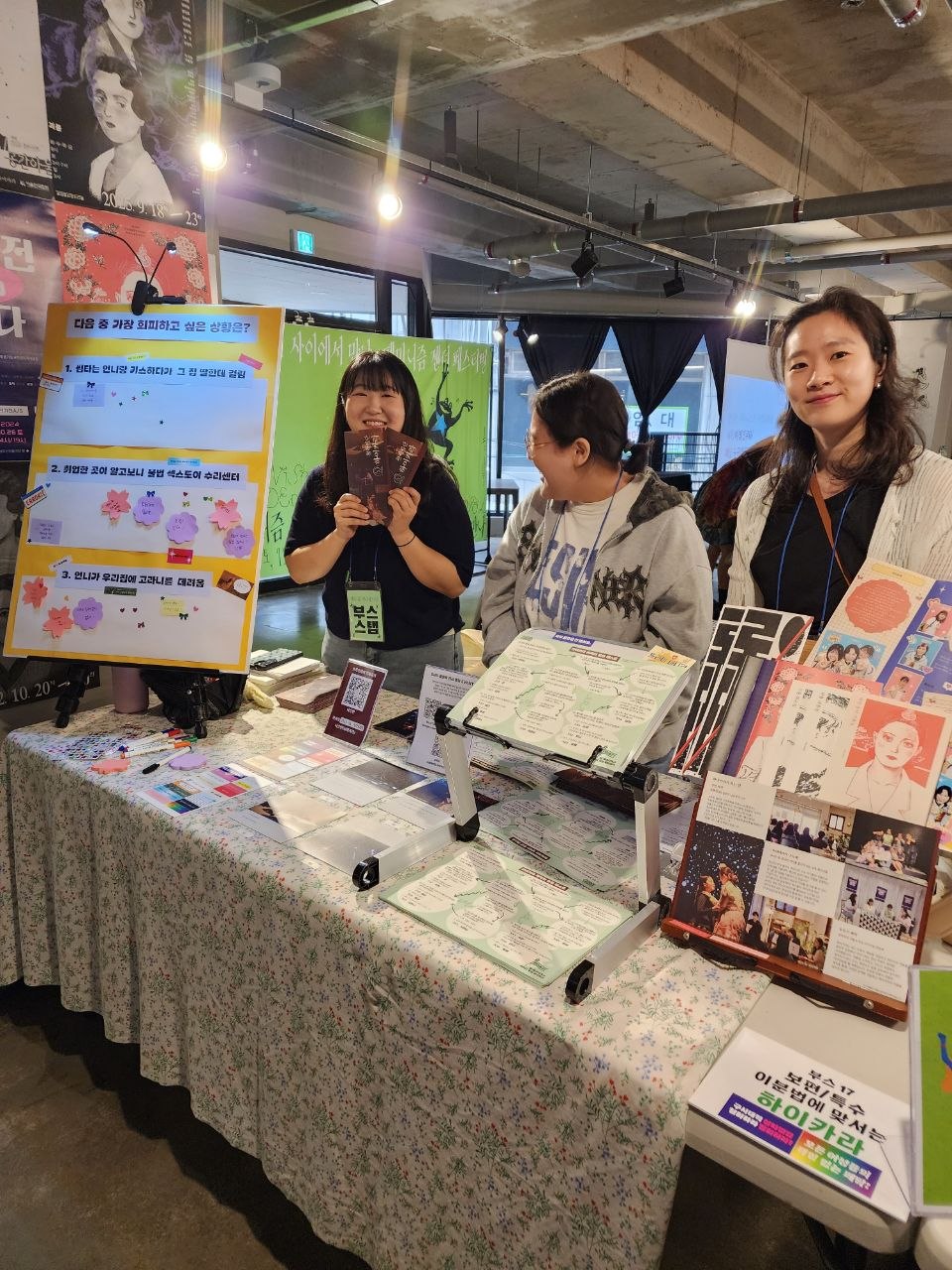 부스 앞에서 카메라를 보며 환히 웃고 있는 하이카라 부스 운영자들의 모습