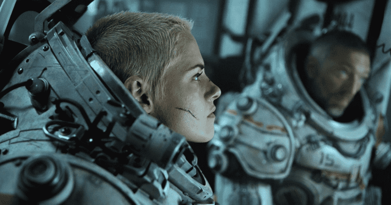 매우 짧은 금발을 한 여성이 우주복처럼 생긴 잠수복을 입고있다. 영화의 한 장면.