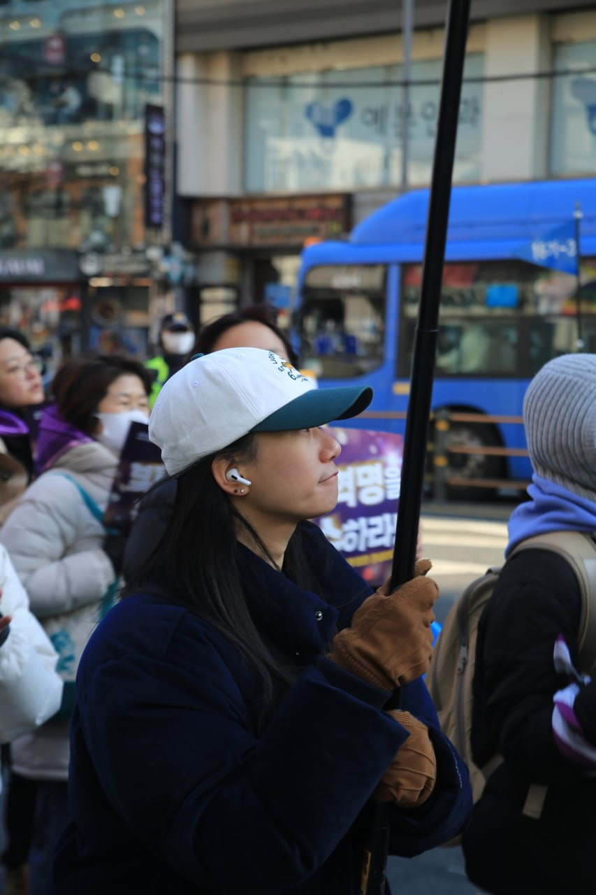 사진 43. 민우회 활동가 류가 민우회 깃발을 들고 행진에 참여하고 있다.