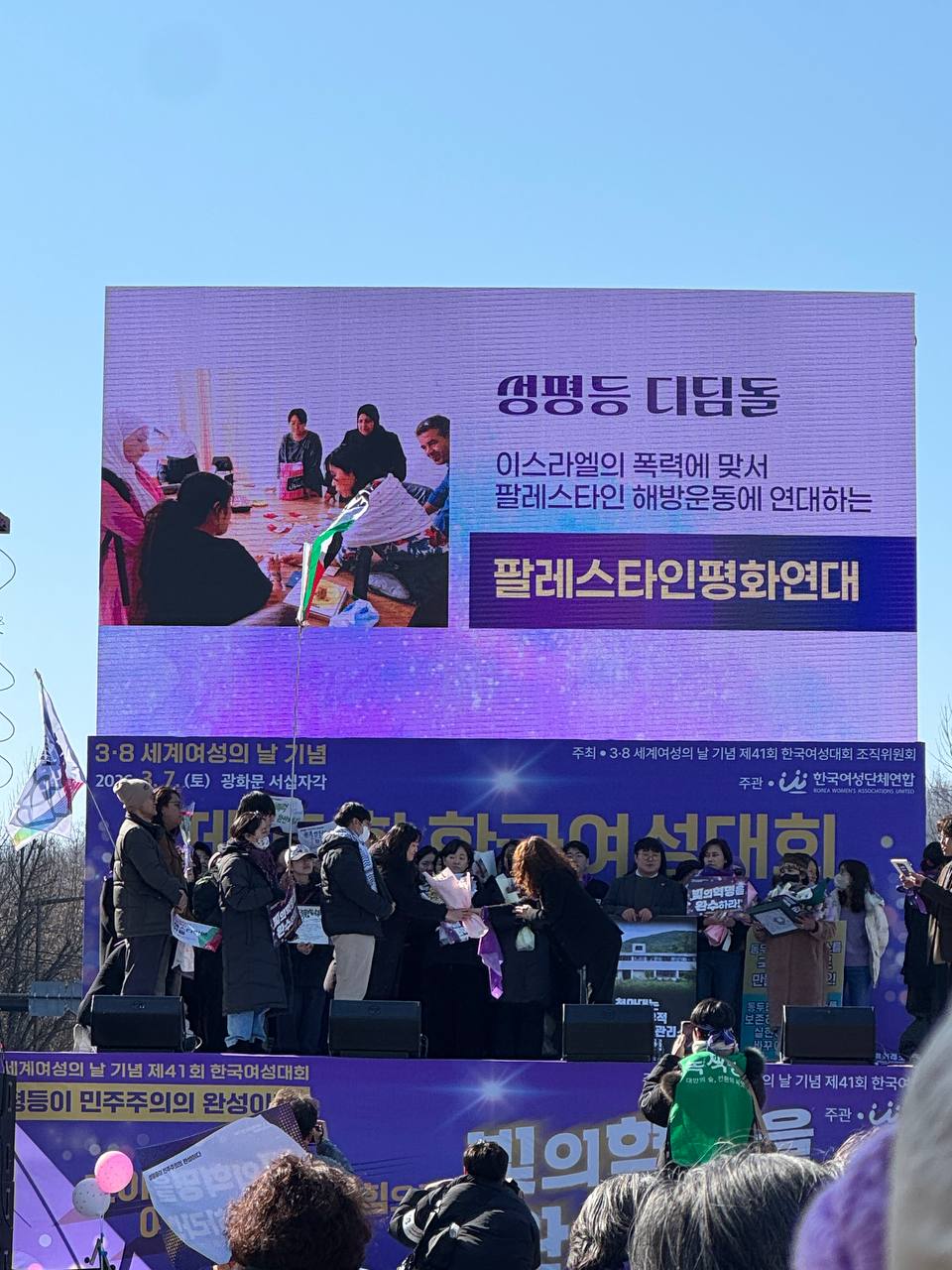 사진 34. 무대에서 올해의 성평등 디딤돌을 발표하고 있다. 수상자 이름 팔레스타인평화연대가 무대 스크린에 게시되어있다.