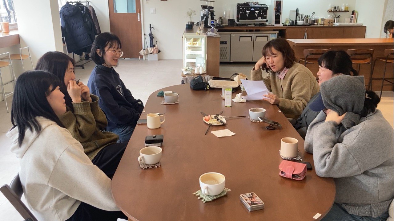 정관퀴즈 하는 장면, 여섯명의 활동가가 카페 테이블에 둘러앉아있다