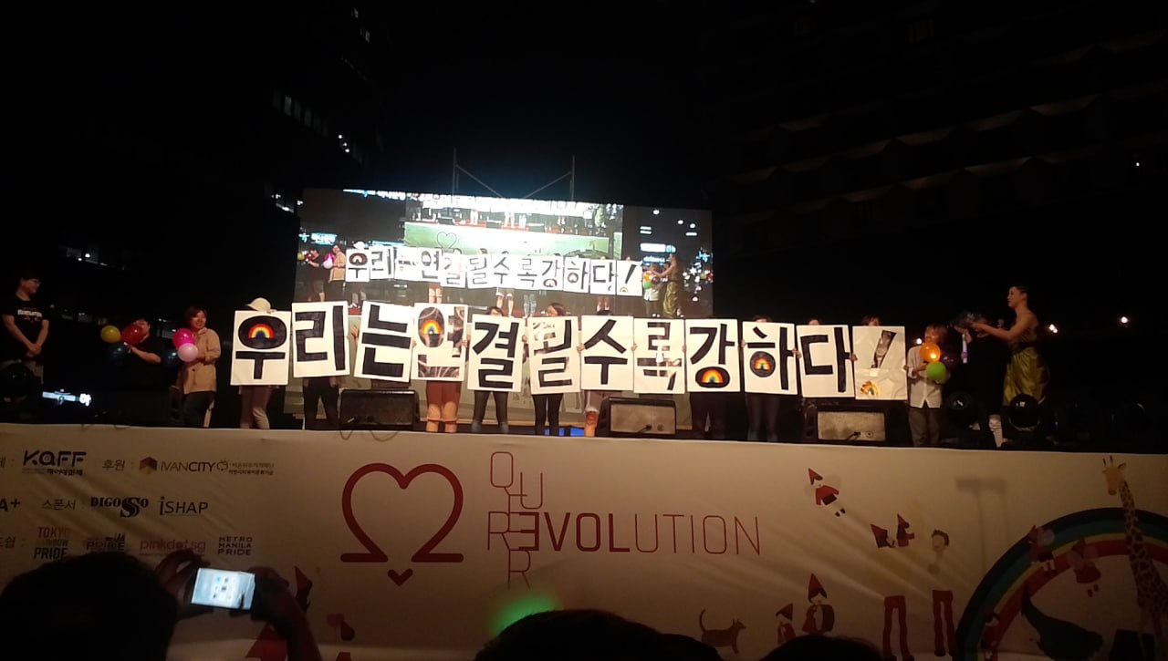 우리는 연결될수록 강하다 라는 문구가 한글자씩 적힌 판넬을 들고 있는 활동가들의 모습