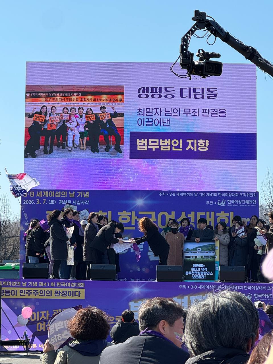 사진 32. 무대에서 올해의 성평등 디딤돌을 발표하고 있다. 수상자 이름 법무법인 지향이 무대 스크린에 게시되어있다.