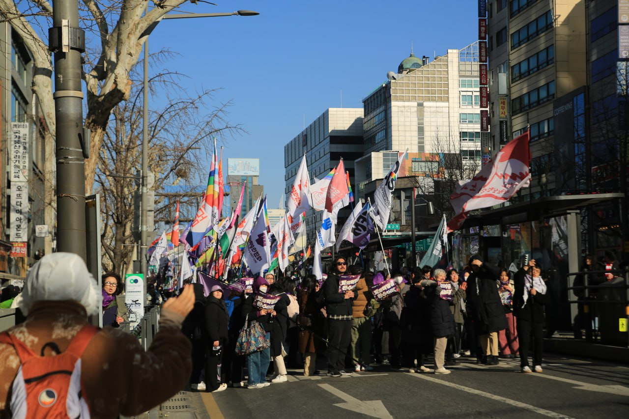 사진 40. 행진에 참여한 페미니스트 시민들이 트럭 앞에 다양한 깃발을 들고 구호를 외치고 있다.