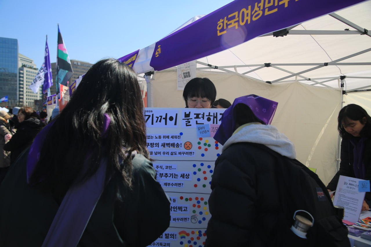 사진 2. 페미니스트들이 활동가로부터 기꺼이 불편해지기 캠페인에 대한 설명을 듣고, 바꾸고 싶은 장면에 스티커를 붙이고 있다.