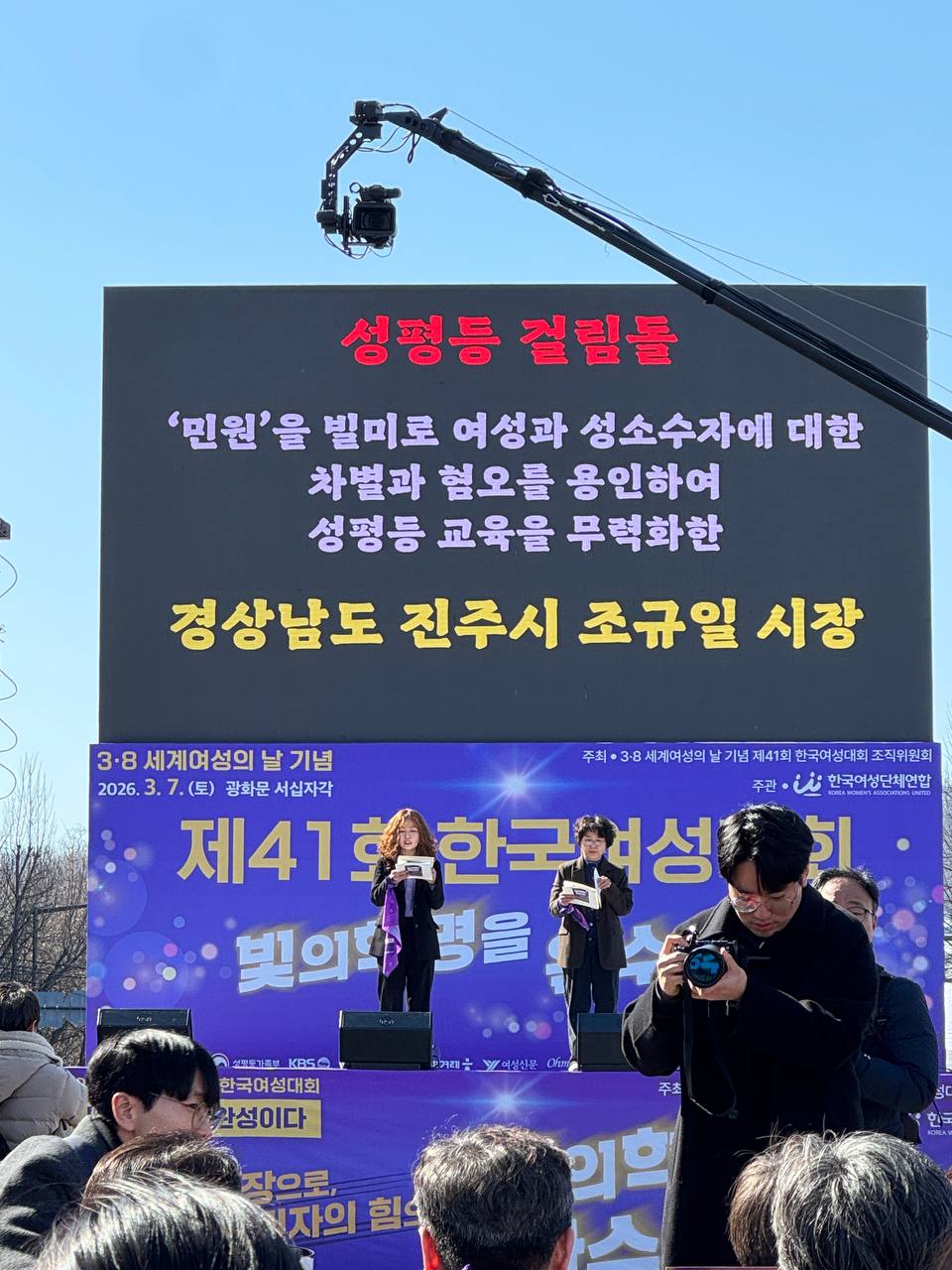 사진 26. 올해의 성평등 걸림돌을 무대에서 발표하고 있다. 경상남도 진주시 조규일 시장이 스크린에 게시되어있다.