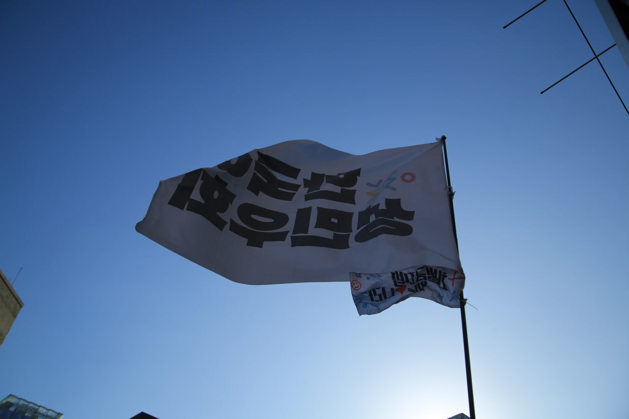 사진 48. 한국여성민우회라고 쓰인 깃발이 거리에서 힘차게 흩날리고 있다.