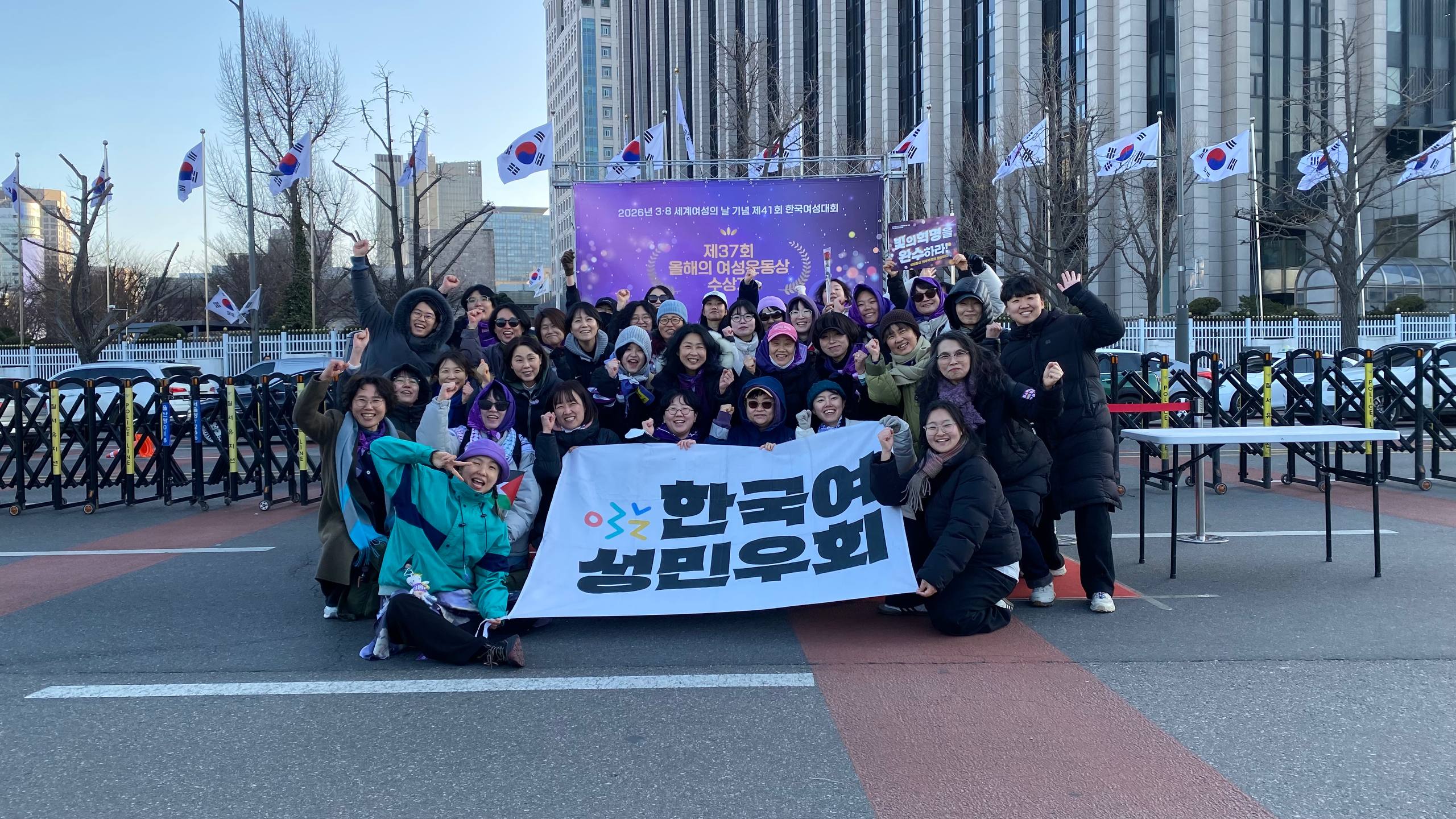 사진 49. 민우회 본부와 지부 활동가가 여성대회의 포토부스 앞에서 힘차게 웃으며 단체 사진을 찍고 있다.
