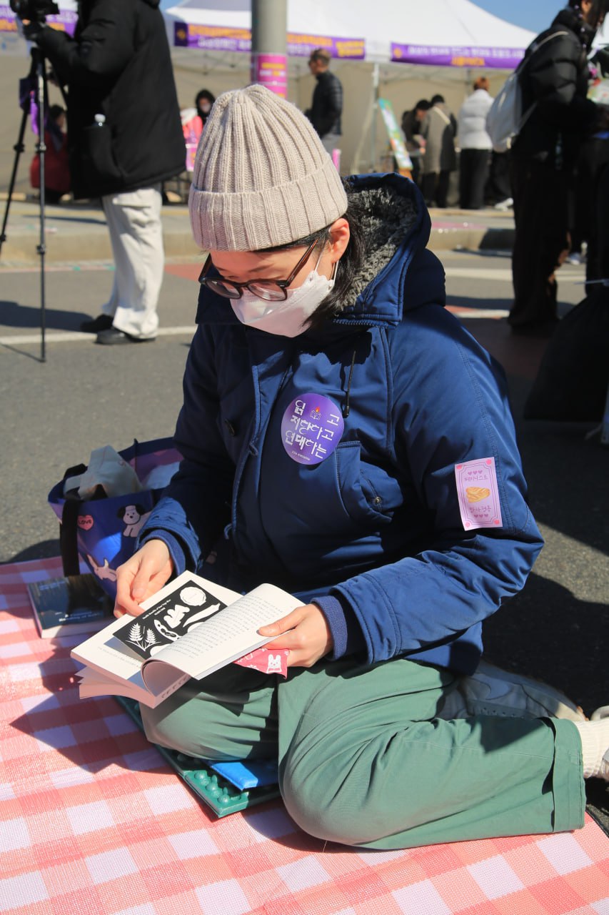 사진 18. 민우회 부스 옆 빈 장소에서 활동가와 페미니스트들이 페미니즘 책을 읽고 있다.