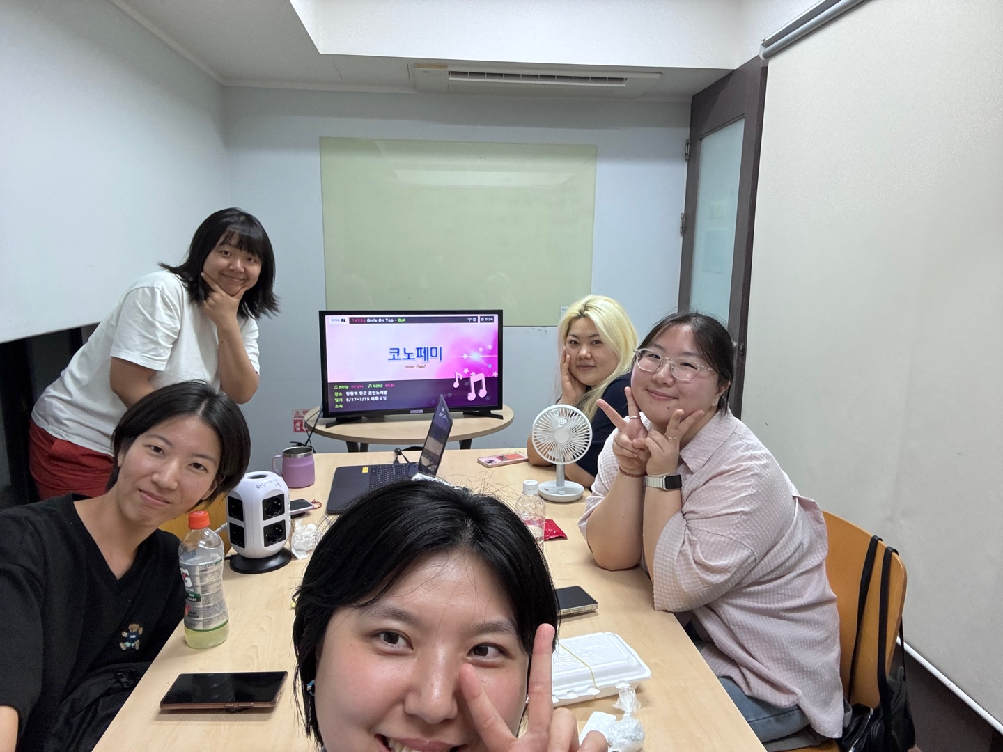 코노페미 첫 모임 단체사진. 사무실에서 다섯 명이 카메라를 보고 웃거나 브이 표시를 하고 있다.