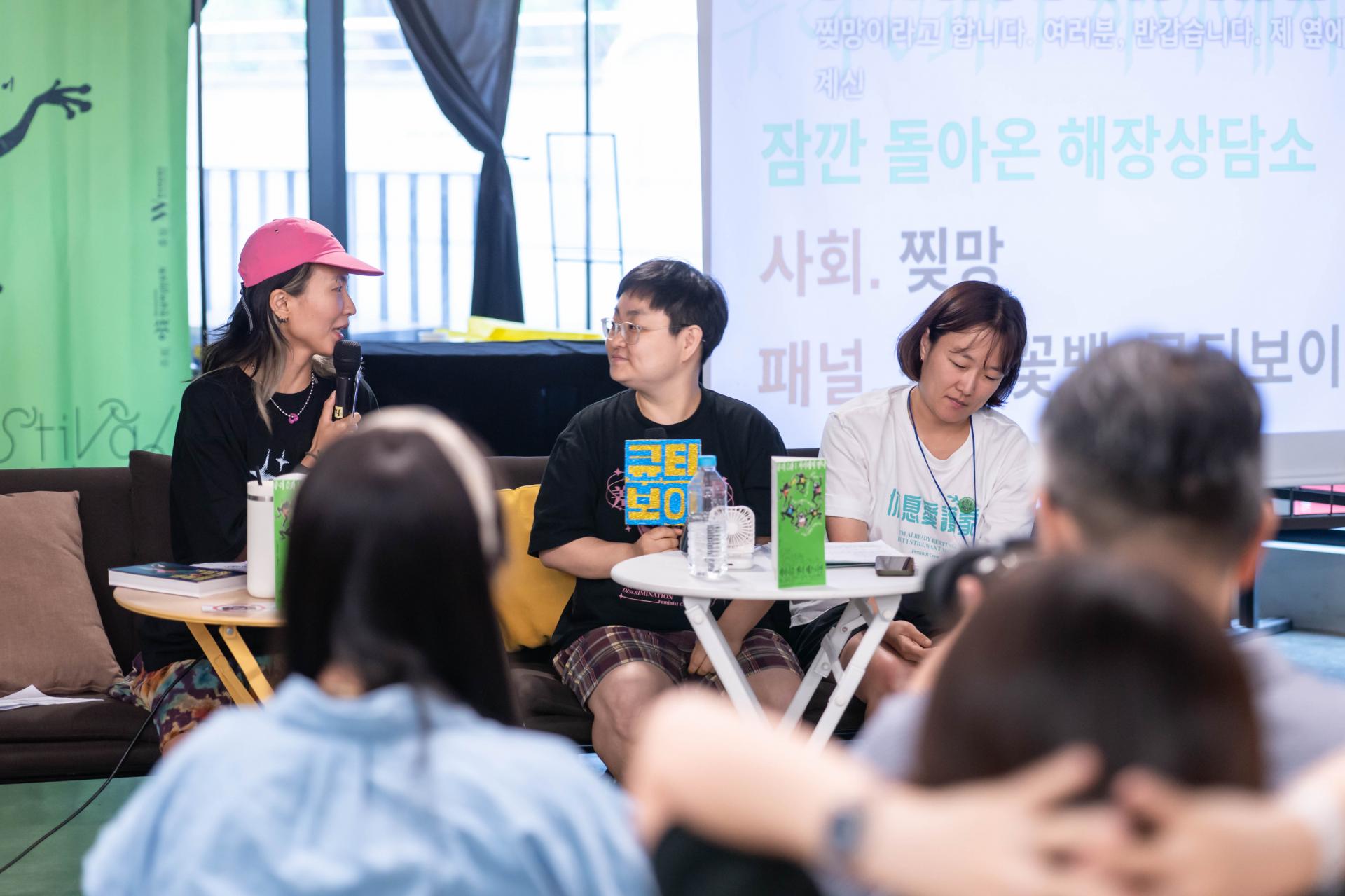 발언 중인 찢망의 모습. 찢망을 미소를 띈 채로 바라보고 있는 큐티보이의 모습.