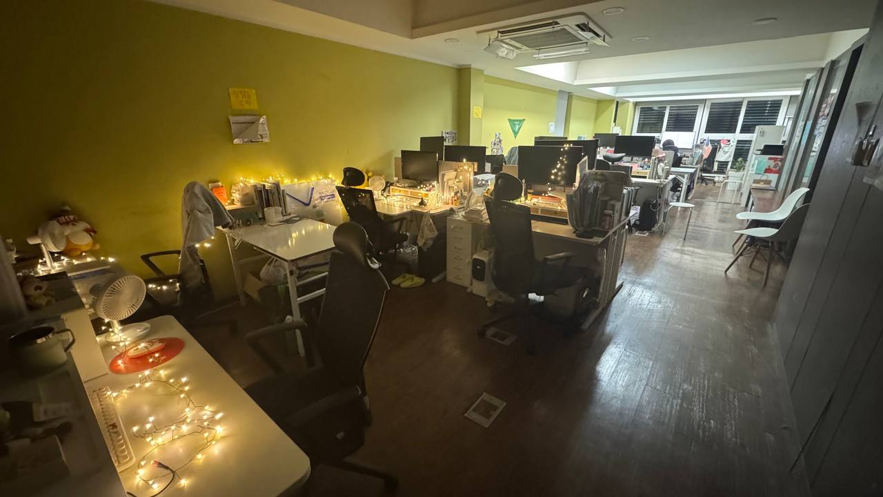 작은 전구 조명을 설치해놓은 사무실 전경. 책상 위에 조명이 은은하게 빛나고 있다.
