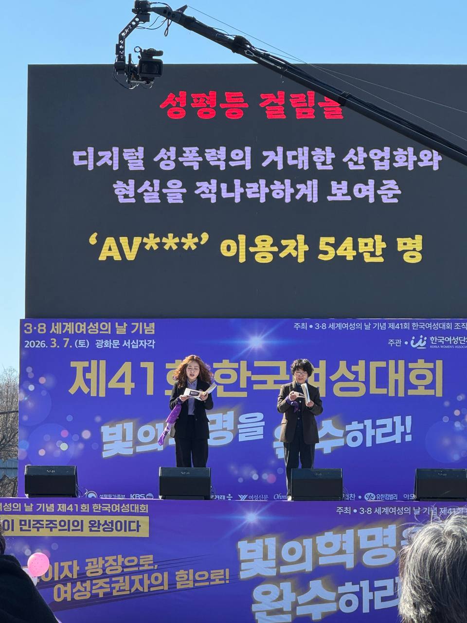 사진 22. 올해의 성평등 걸림돌을 무대에서 발표하고 있다. AV***’ 이용자 54만 명이 스크린에 게시되어있다.