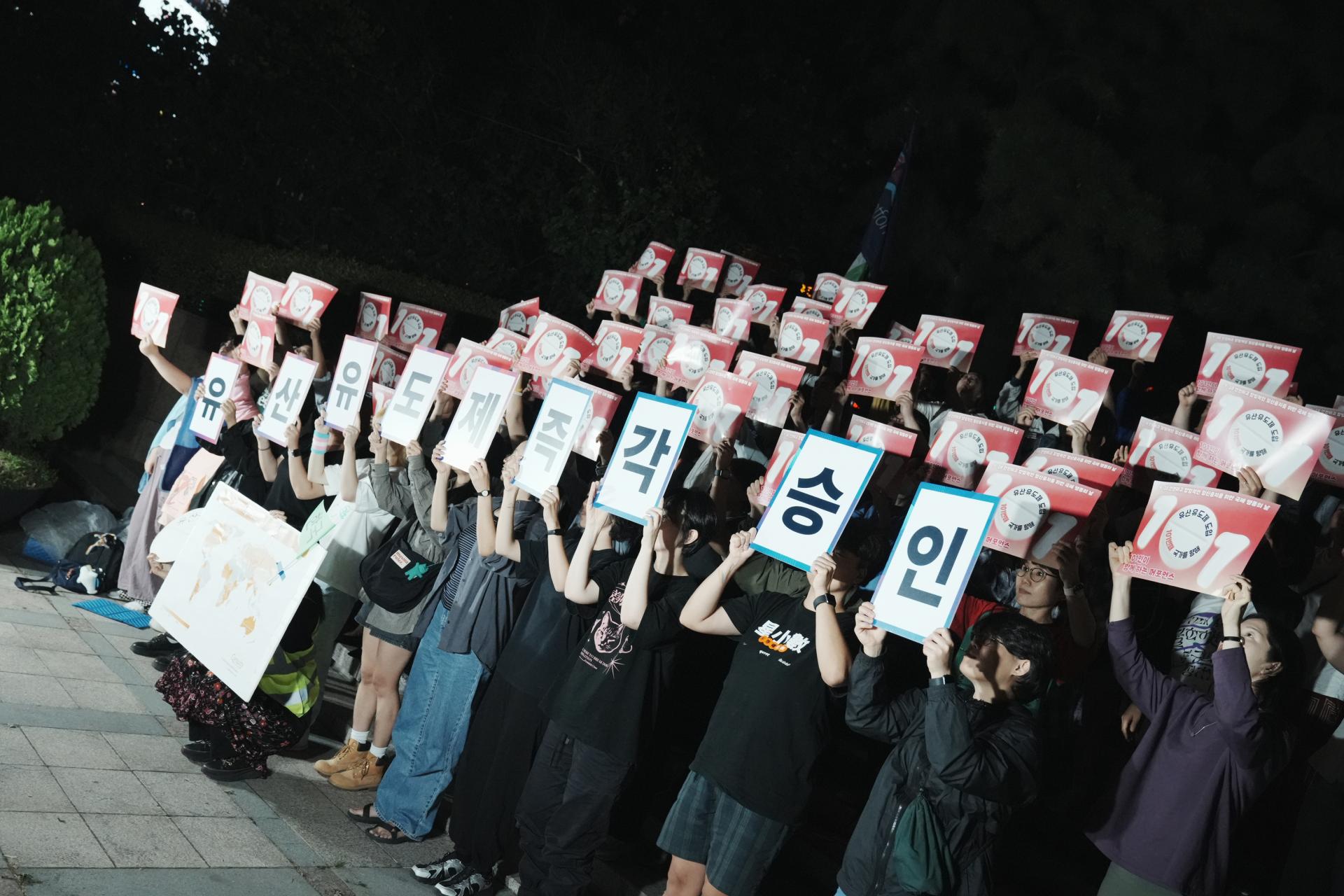 참여자들이 각자에게 주어진 피켓을 들고 단체사진에 임하고 있는 모습. 모두 밝은 얼굴로 유산유도제 도입을 환영하고 있다.