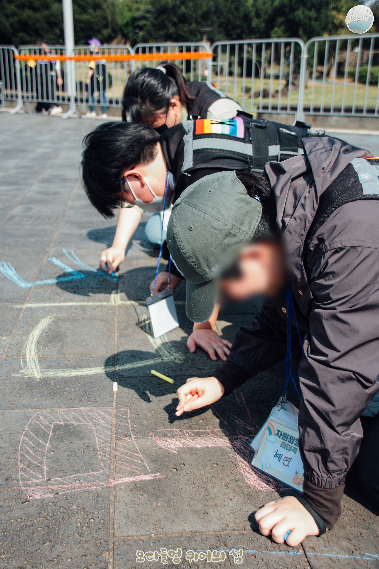 신산공원 바닥에서 분필 퍼포먼스 중인 자원활동가들의 모습