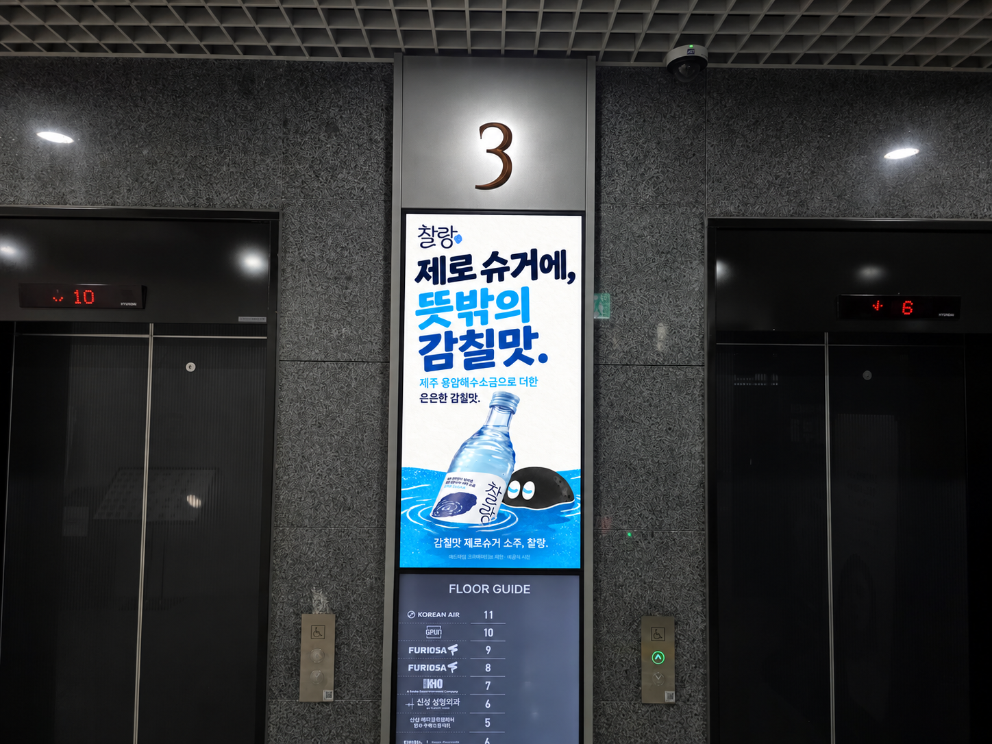 ‘제로 슈거에, 뜻밖의 감칠맛.’ 오피스 엘리베이터 로비 적용 제안. 배경사진: 애드타입 촬영 오피스 로비 목업. 제품·캐릭터·로고 참조: 찰랑 공식 홈페이지. 카피·디자인·목업 편집: 애드타입.