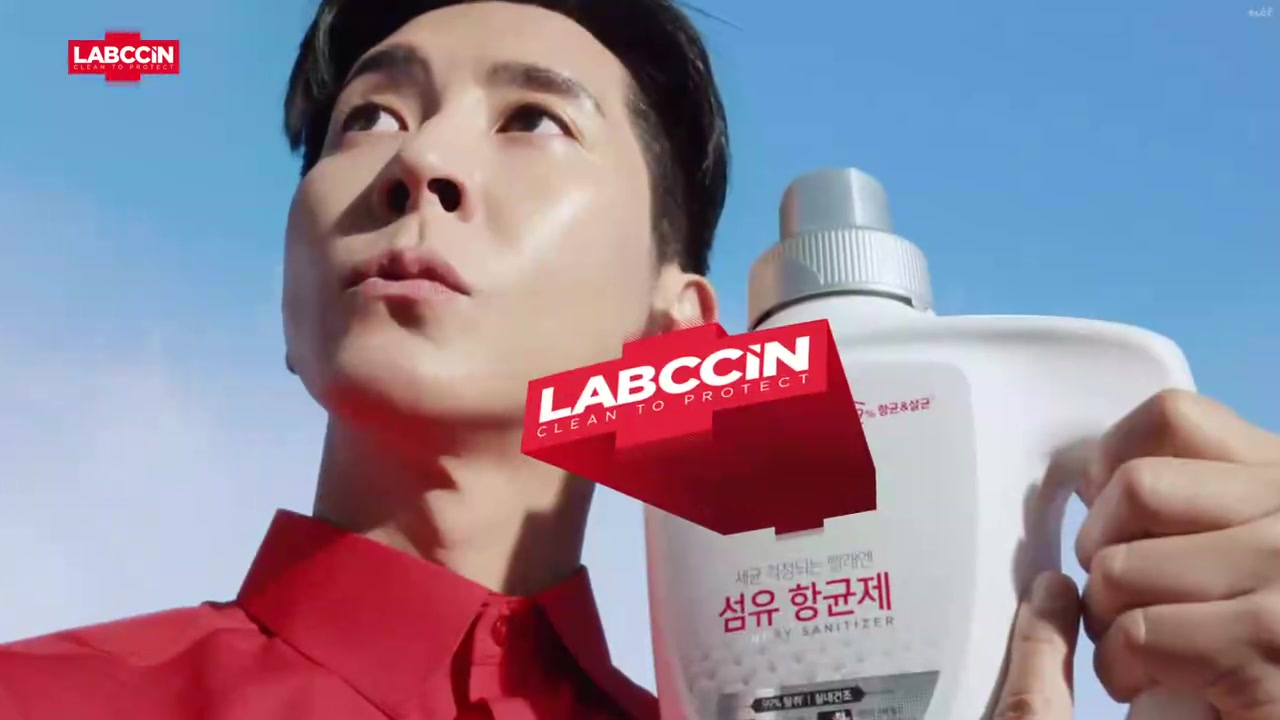 붉은 셔츠를 입은 모델이 하늘을 배경으로 랩신 섬유항균제 제품을 들고 있는 장면