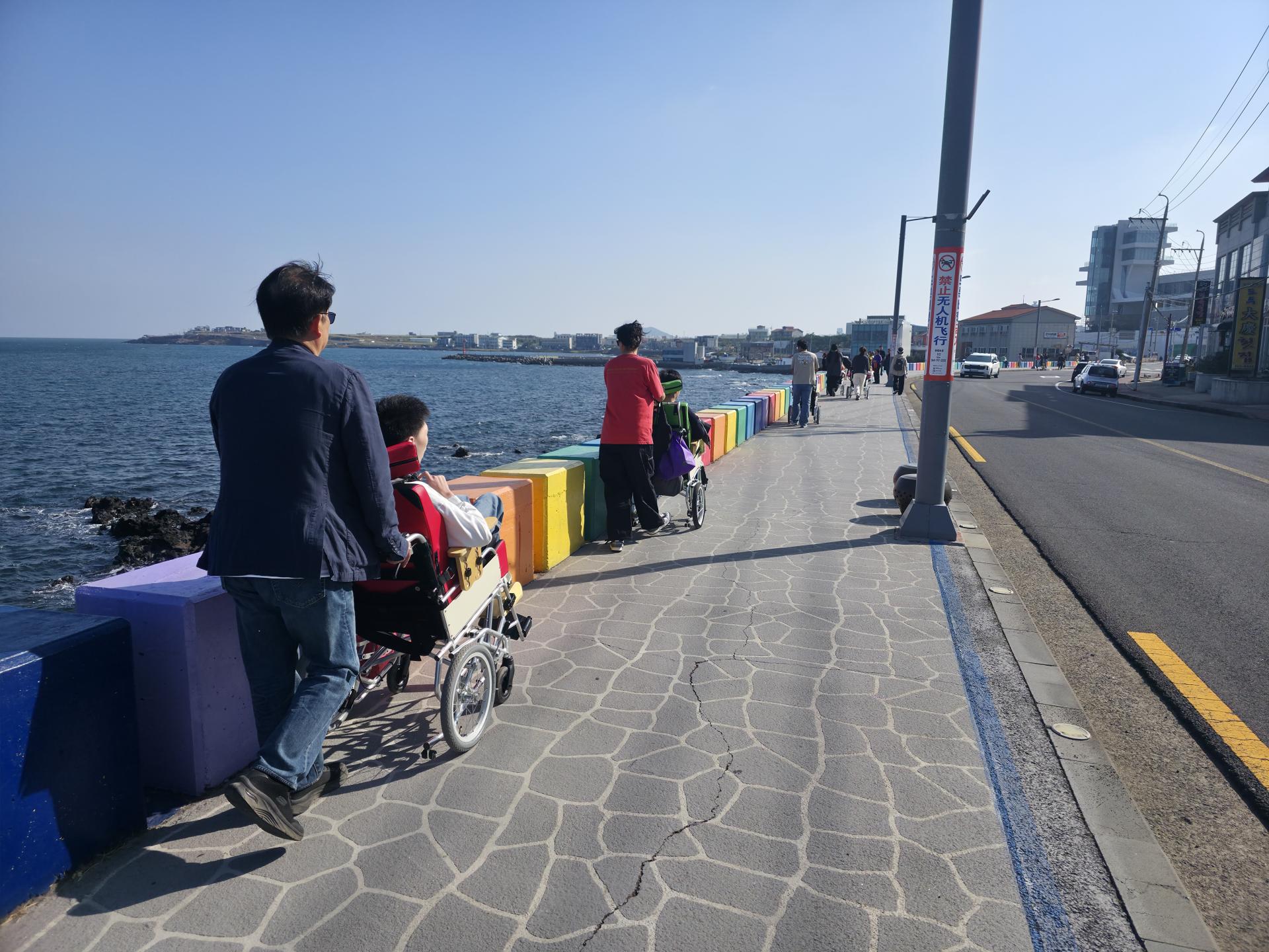 무지개 해안도로를 산책길을 거닐고 있는 이용자와 직원들