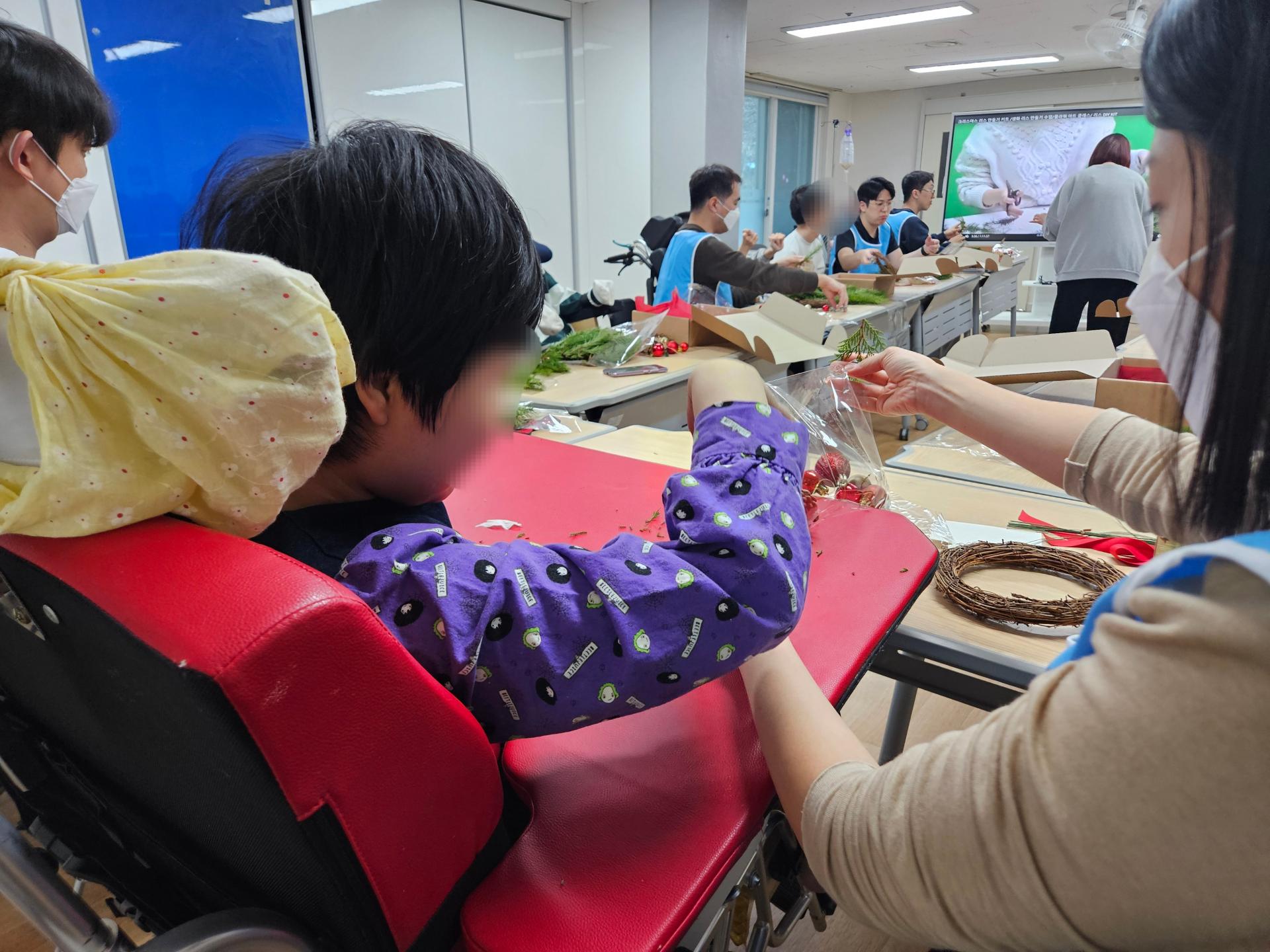 이용자와 함께 생화리스를 만드는 봉사자