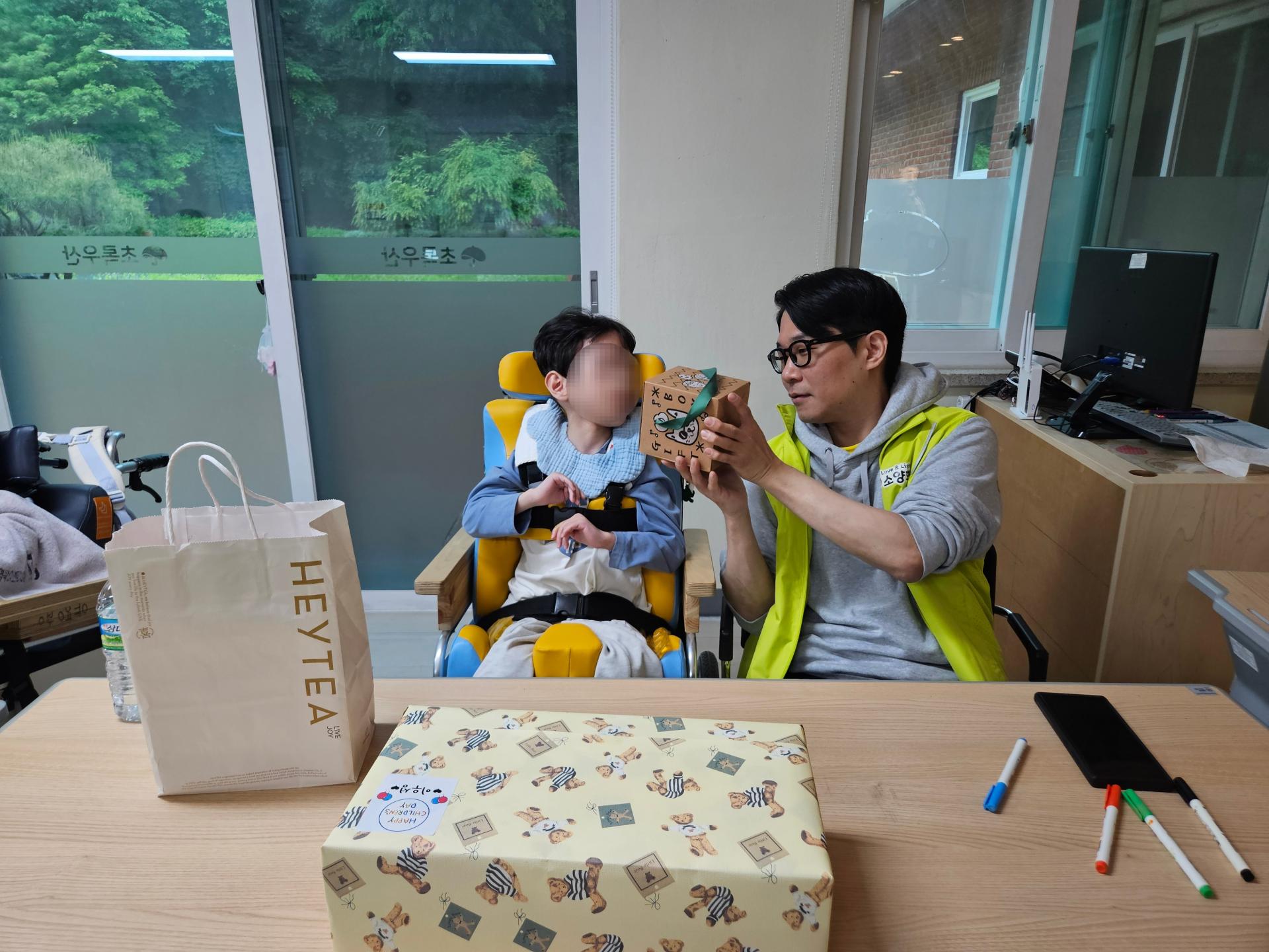 함께 선물을 열어보는 이용자와 봉사자